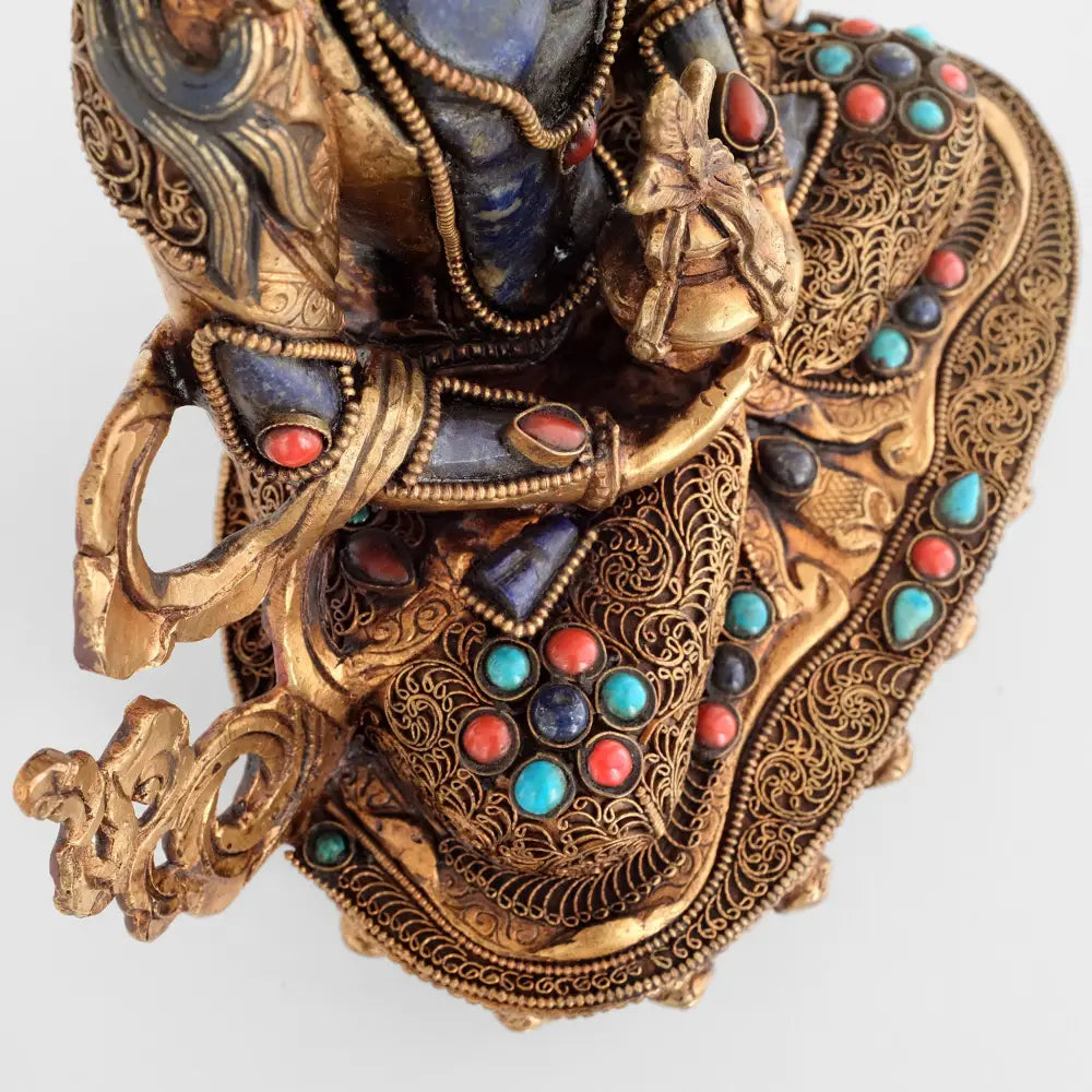Amitayus Buddha hält die Amrita Vase in seinen Händen. Sein Gewand und die Oberseite seines Sockels sind mit feinen Filigran Verzierungen in spiralförmiger Anordnung besetzt. Akzentuiert mit Türkis und Koralle.