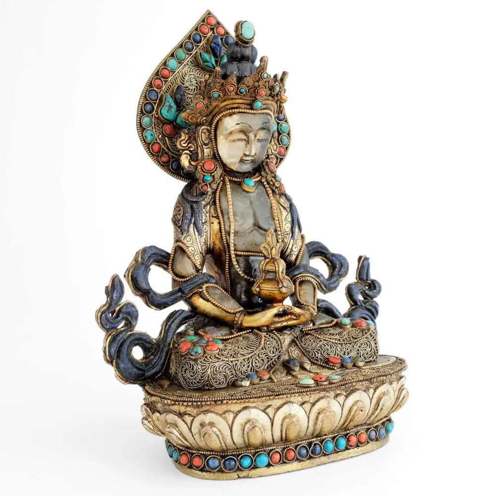 Verschnörkelte Buddha-Statue mit Akzenten in Türkis und Koralle.
