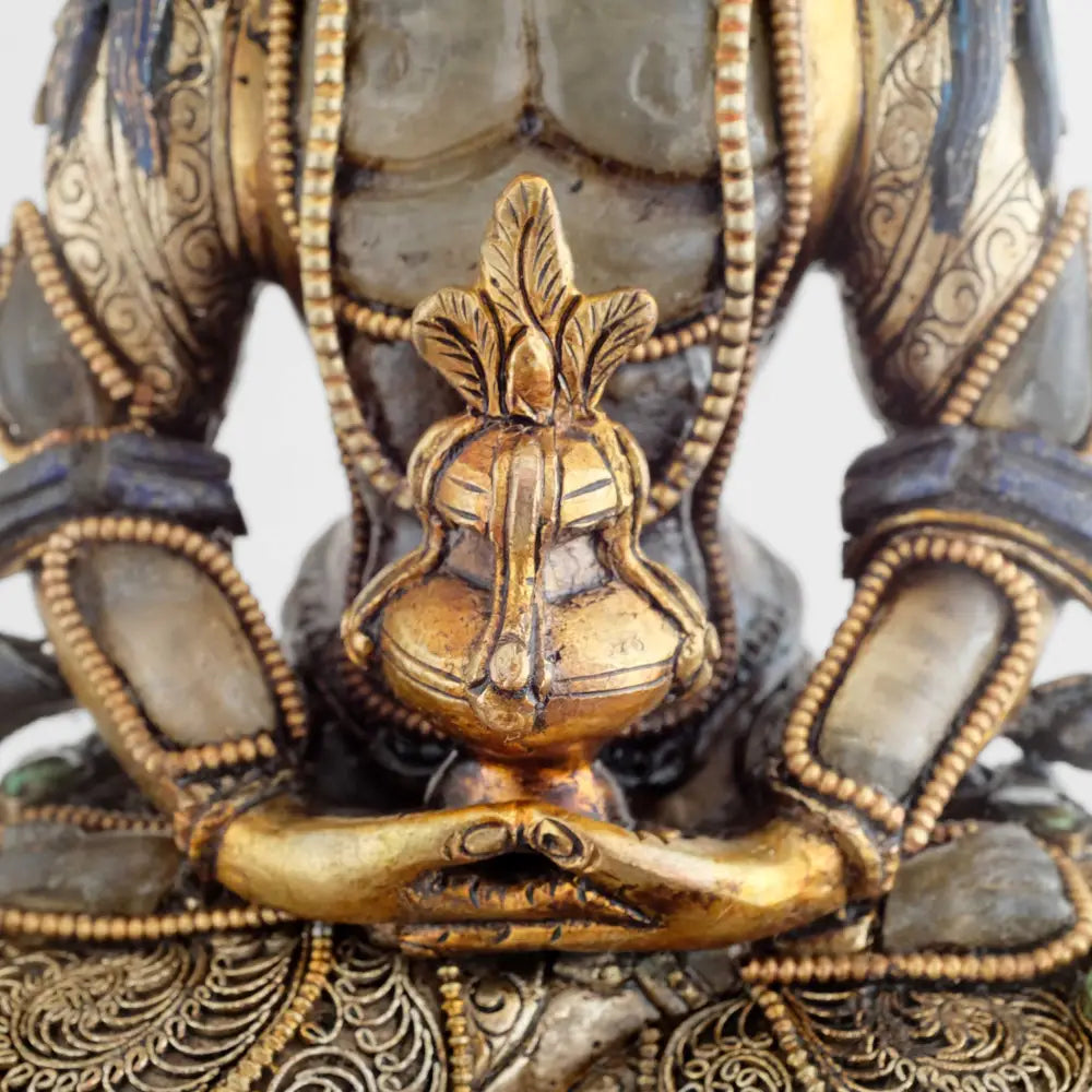 Amitayus hält die Hände in der Meditationsgeste Dhyana Mudra und darin die Amrita Vase mit dem Nektar der Unsterblichkeit.