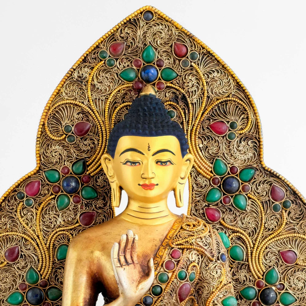 Detail des Gesichts von der Amoghsiddhi Buddha Statue vor der mandelförmigen verzierten Aureole.