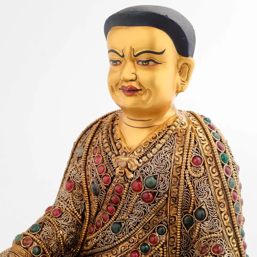 Guru Marpa, sein Gesicht ist in Gold gefasst. Sein Gesichtsausdruck verbindet Strenge mit Güte.
