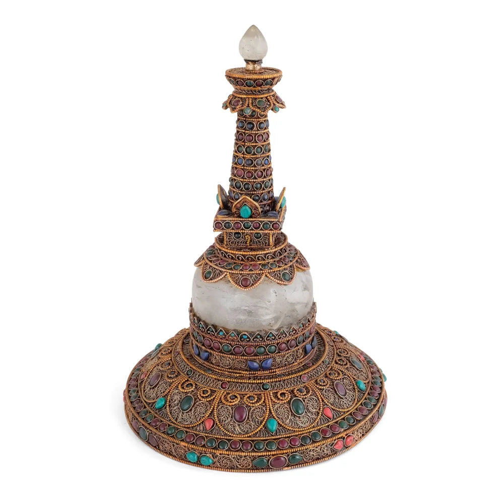 Runde Stupa aus Kupfer und Quartzkristall. Das Kupfer ist mit feinem Filigran in spiralförmigen Ornamenten besetzt, versilbert und vergoldet. Akzentuiert mit farbigen Steinen.