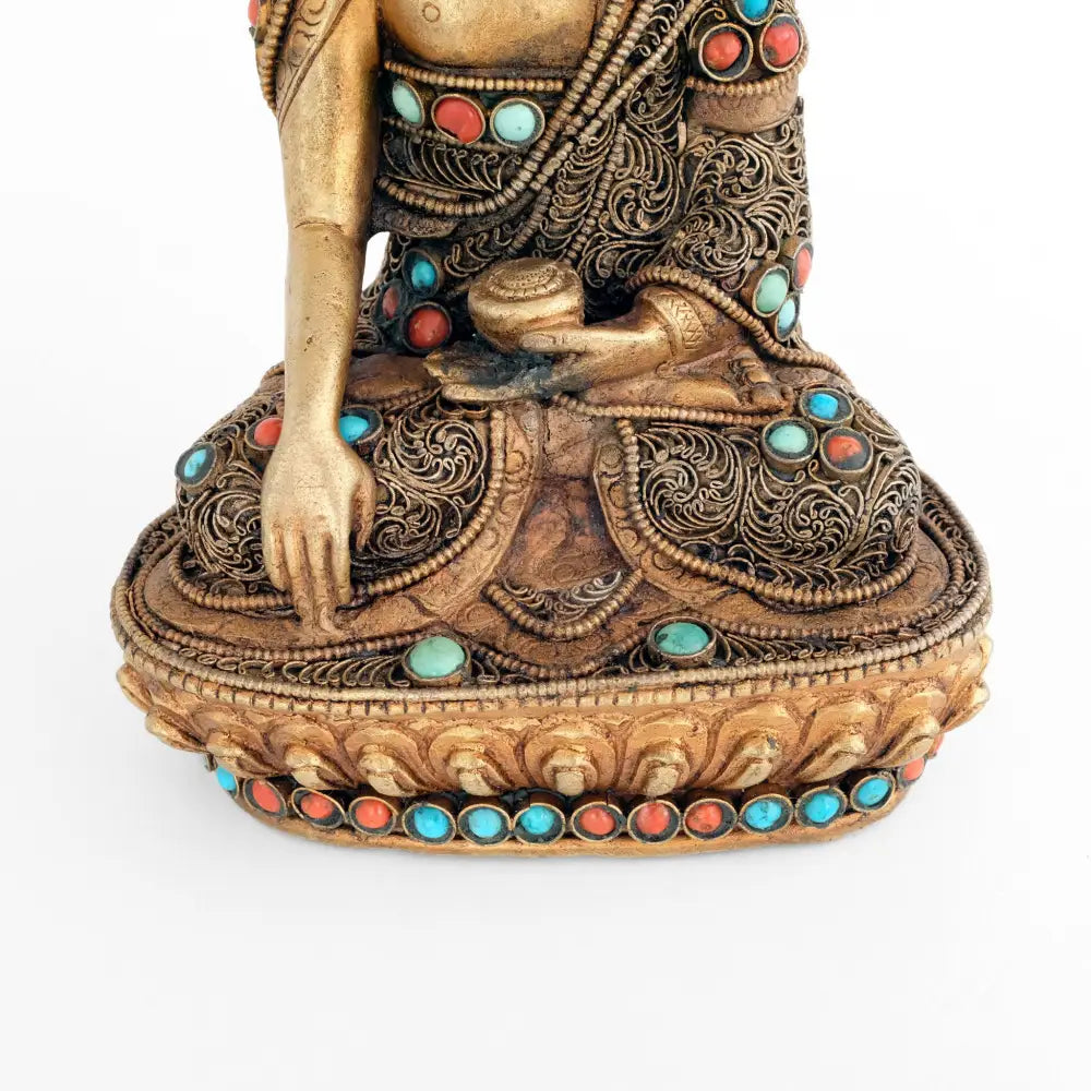 Shakyamuni Buddha Statue, seine rechte Hand im Bhumipharsa Mudra. Seine Robe ist besetzt mit versilberten Filigran in spiralförmigen Elementen. Akzentuiert mit Koralle und Türkis.