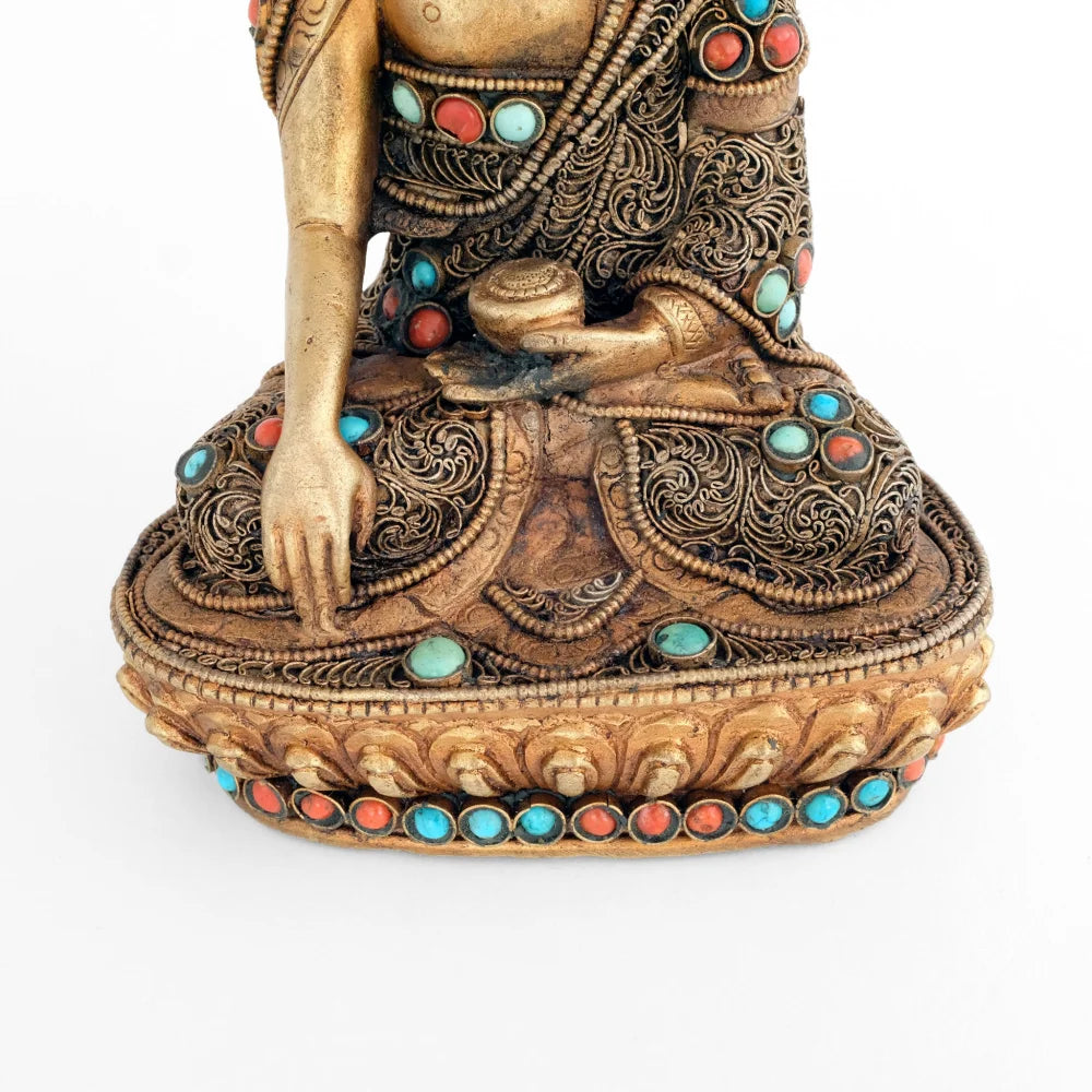 Shakyamuni Buddha Statue, seine rechte Hand im Bhumipharsa Mudra. Seine Robe ist besetzt mit versilberten Filigran in spiralförmigen Elementen. Akzentuiert mit Koralle und Türkis.