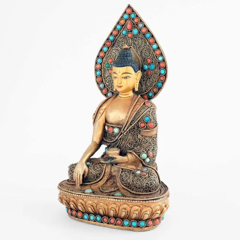 Shakyamuni Buddha Statue mit tropfenförmigem Nimbus. Seine Robe und der Hintergrund sind mit feinem Filigran verziert und mit Türkis, Koralle besetzt.
