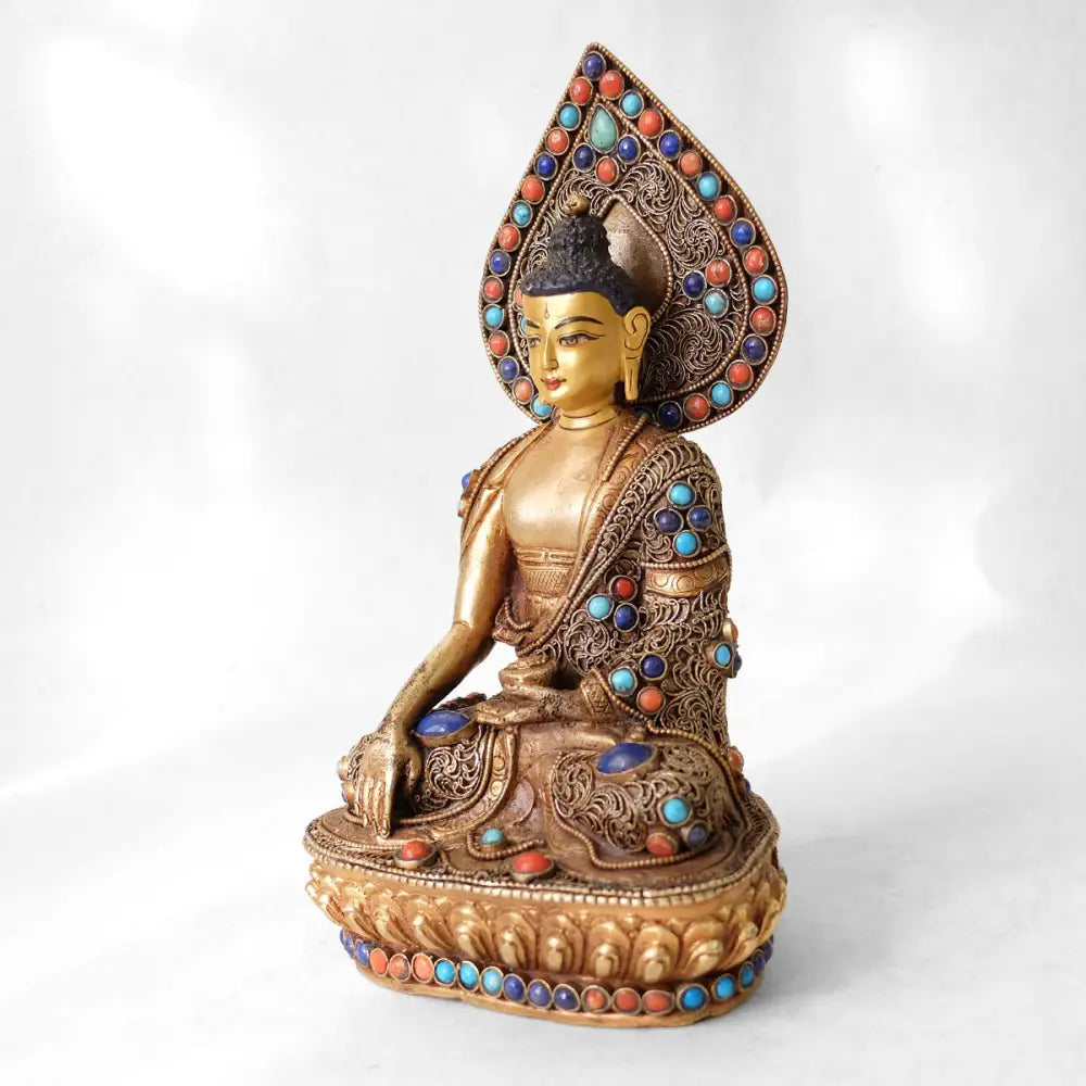 Shakyamuni Buddha Figur, aus Kupfer gegossen, mit feinem Filigran verziert, vergoldet und versilbert, mit Türkis, Koralle und Lapislazuli besetzt. Das Gesicht ist in Gold gefasst.