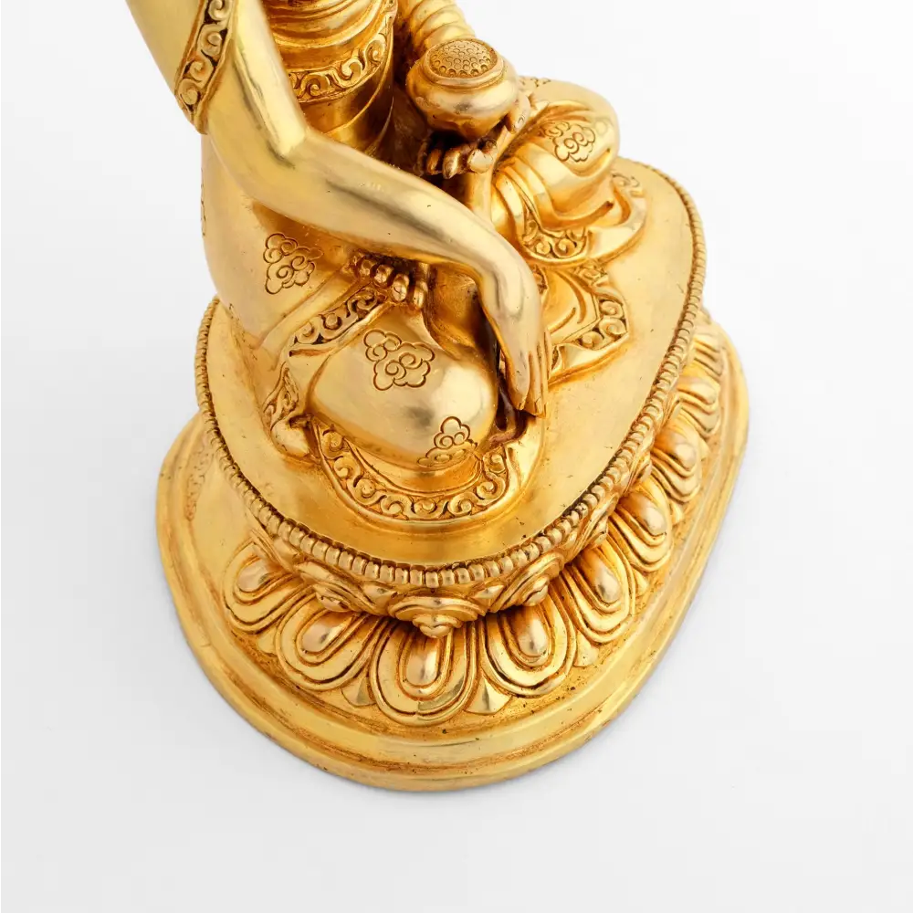 Detail der ziselierten goldenen Buddha-Statue. Seine rechte Hand berührt die Erde.