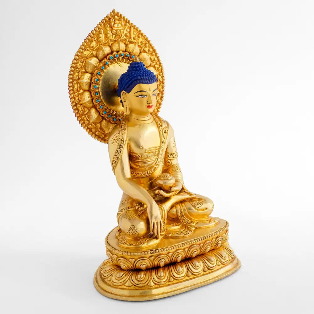 Goldene Shakyamuni Buddha Statue, hinter seinem Kopf ein tropfenförmiger Nimbus mit türkisem Kranz.