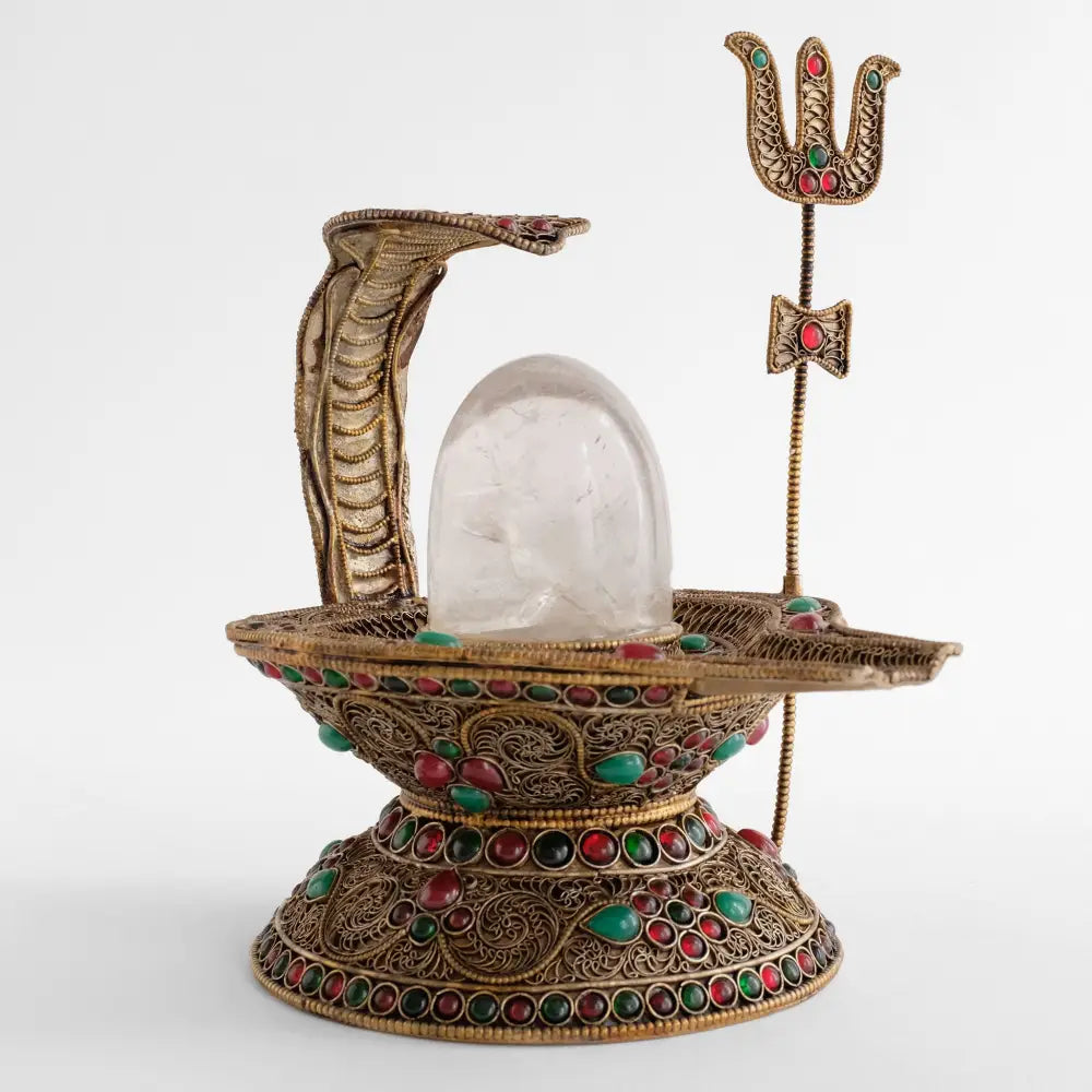 Shiva Lingam Statue mit einer Kobra die über den Kristall Lingam ragt und einem Dreizack, das Symbol Shivas.