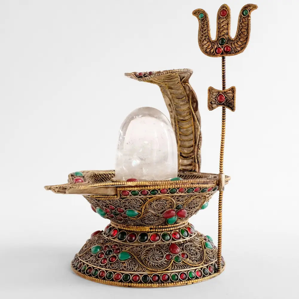 Shiva Lingam Statue mit versilberten Filigran Elementen sowie roten und grünen Steinen.
