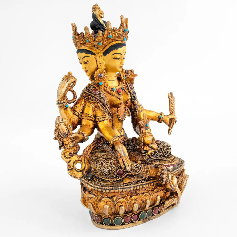Vasudhara Devi, Göttin mit drei Gesichtern und 6 Armen. Die oberen Hände halten einen Rosenkranz und das Buch der Weisheit, Prajnaparamita. Ihr rechter Fuß ruht auf einer kleinen Vase. Ihre Robe ist verziert mit feinen Filigran Ornamenten.