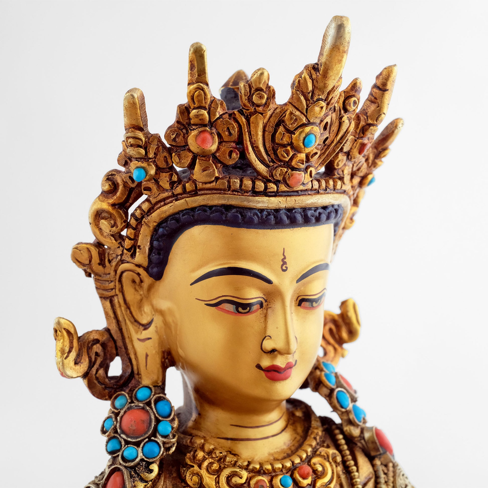 Detail, das Gesicht der Akshobhya Buddha Figur ist in Gold gefasst. Er trägt eine 5-zackige Krone und den vollen Schmuck eines Bodhisattva. 