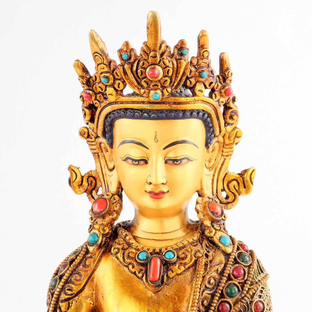 Akshobhya Buddha Statue, close up picture. The face is set in gold. He wears the crown and full ornaments of a bodhisattva.