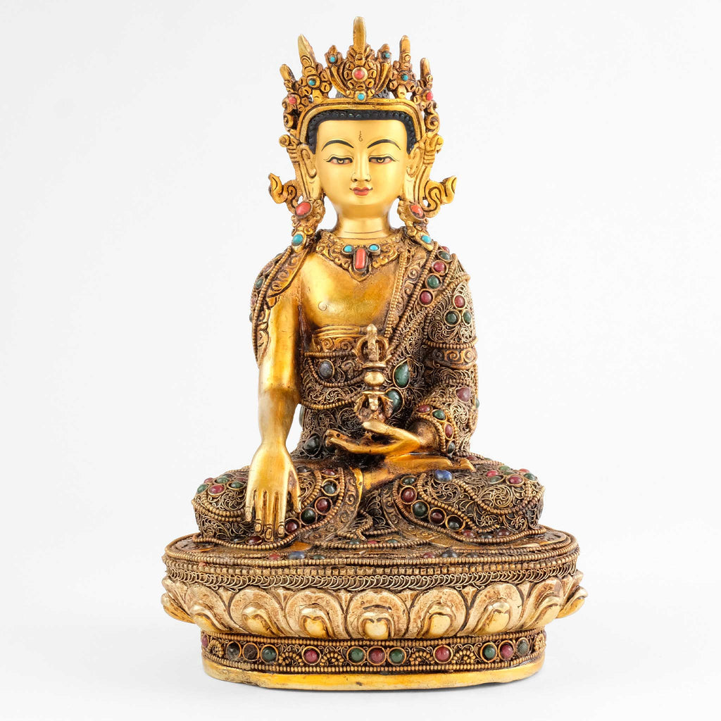 Akshobhya Buddha Statue. He is wearing the crown and full ornaments of a bodhisattva. The figure is decorated with filigree, silver- and gold-plated, set with colored stones.