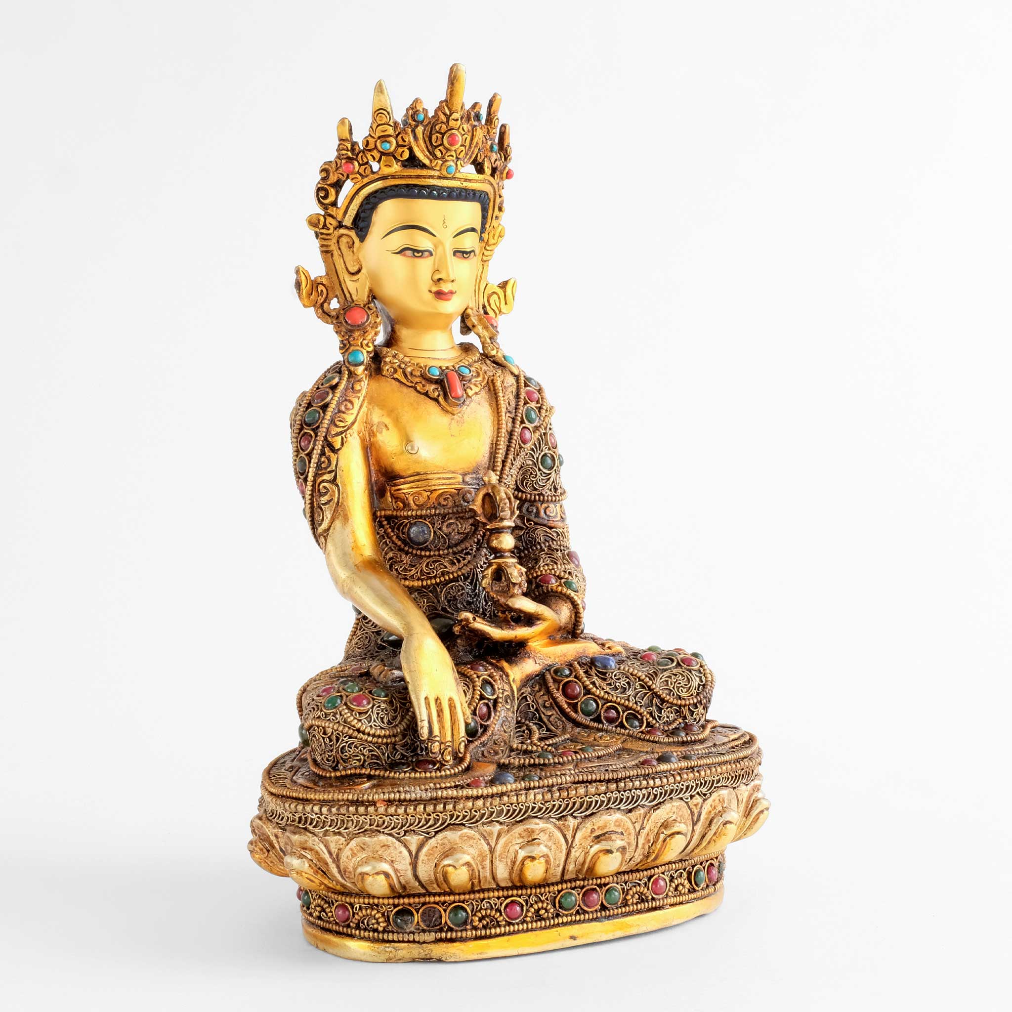 Akshobhya Buddha statue, touching earth with his right hand, holding a vajra in his left. His robe is decorated with filigree, silver- and gold-plated and set with colored stones.