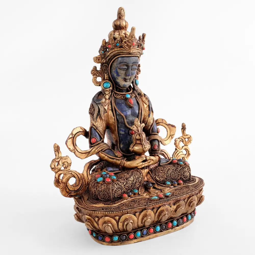 Von Hand aus Lapislazuli geschnitzt, fangen die feinen Gesichtszüge und die kunstvollen Details der Amitayus Buddha Statue die Essenz der Erleuchtung selbst ein. Sein Gewand ist mit feinem Filigran verziert, besetzt mit Türkisen, Korallen und Lapislazuli.