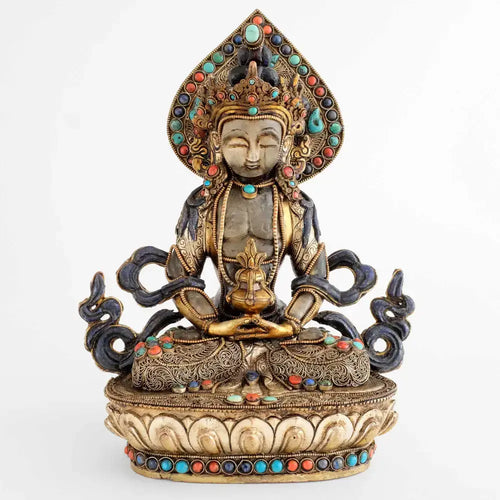 Amitayus Figur, aus Kupfer gegossen, Kopf und Körper aus Kristall geschnitzt, verziert mit feinen Filligranmotiven, versilbert und vergoldet, besetzt mit Lapislazuli, Koralle und Türkis.