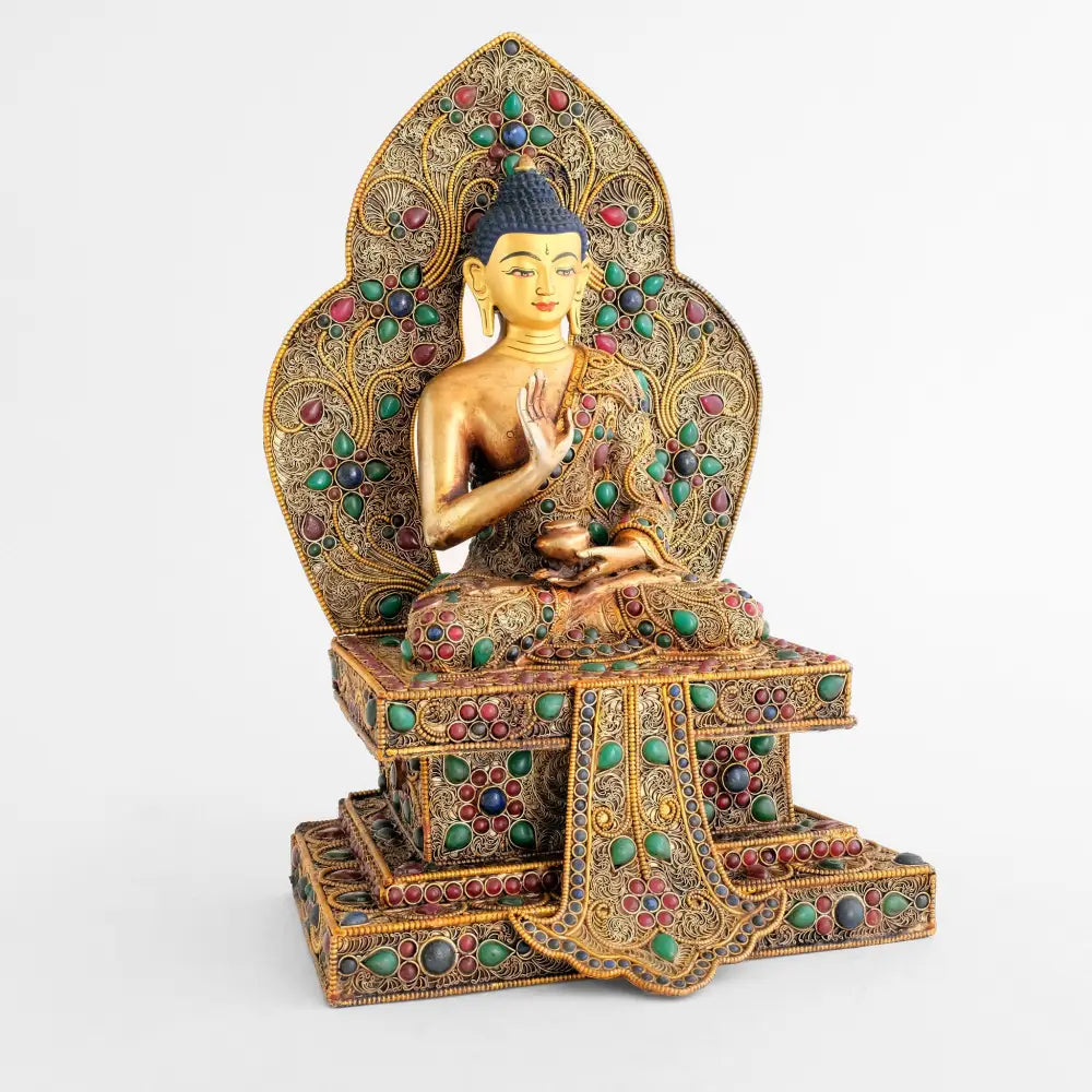 Amoghsiddhi Buddha Statue auf einem mehrstufigen Sockel mit Aureole.