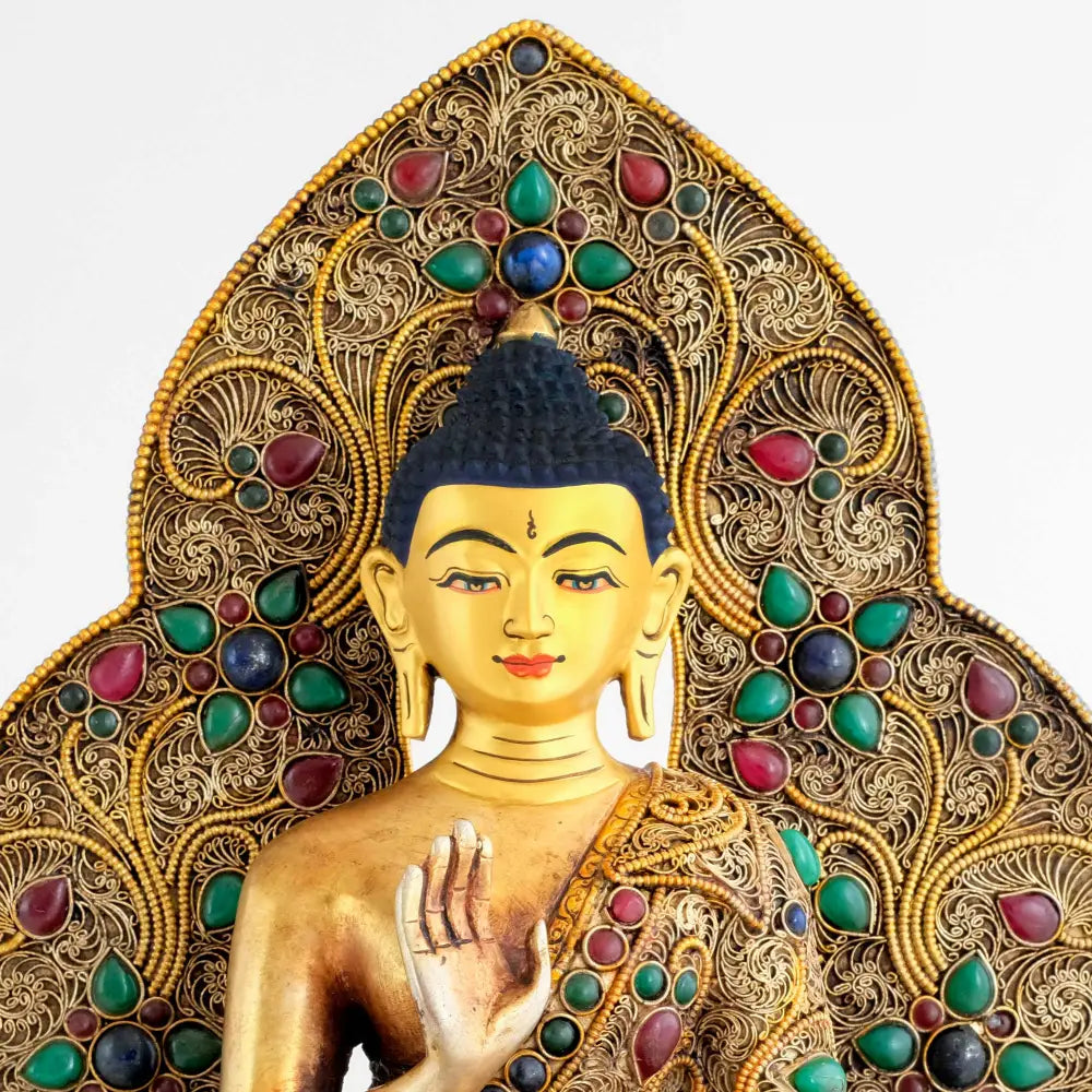 Detail des Gesichts von der Amoghsiddhi Buddha Statue vor der mandelförmigen verzierten Aureole.