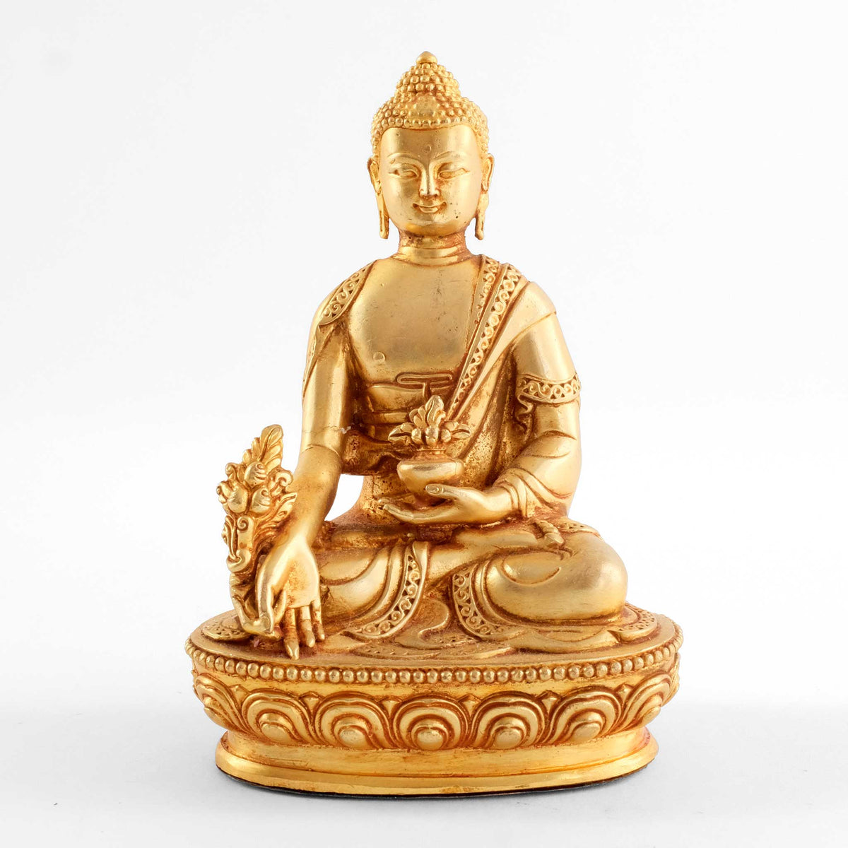 Kleine vergoldete Medizin Buddha Statue. Bhaisajyaguru, der Medizinbuddha, sitzt in padma asana auf einem Lotussockel. Seine rechte Hand ist gesenkt und hält einen Zweig der Myrobalanenpflanze, während seine linke Hand die Medizinschale im Schoß hält.