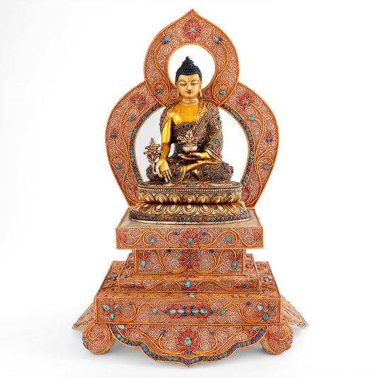 Bhaisajyaguru, der Medizin Buddha trägt eine klösterliche Robe und sitzt im Lotussitz, mit gekreuzten Beinen auf einem geschmückten Thron mit Nimbus. 