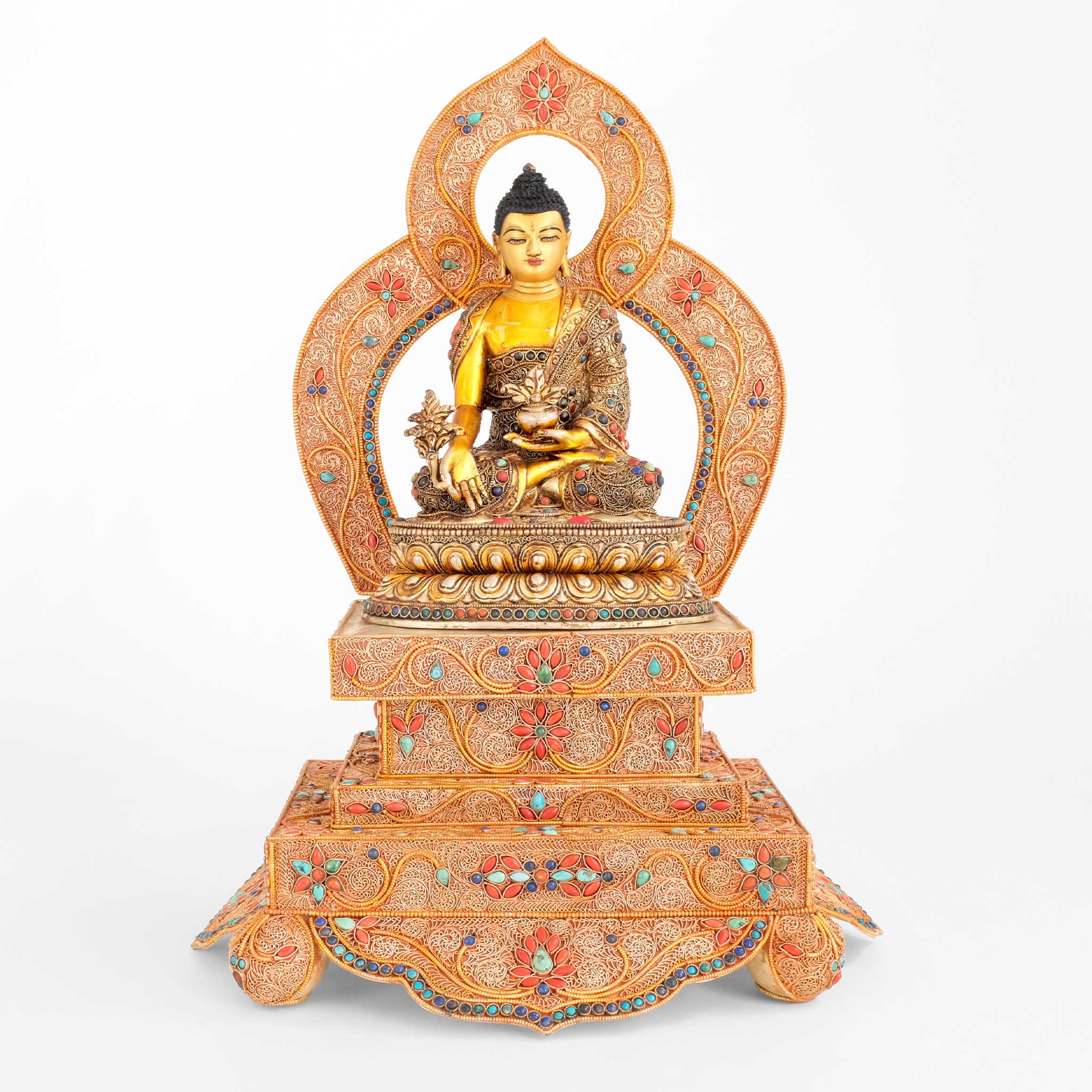 Bhaisajyaguru, Medizin Buddha Statue in Filigran gearbeitet, mit farbigen Steinen besetzt. Auf Thron mit Aureole.