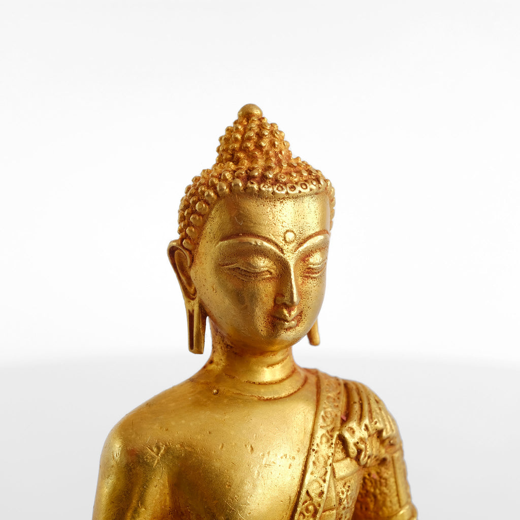 Detail der kleinen Buddha Statue aus vergoldetem Kupfer. Detaillierter Guss. Für das Finish mit rotem, Vermillion Pulver bestäubt.