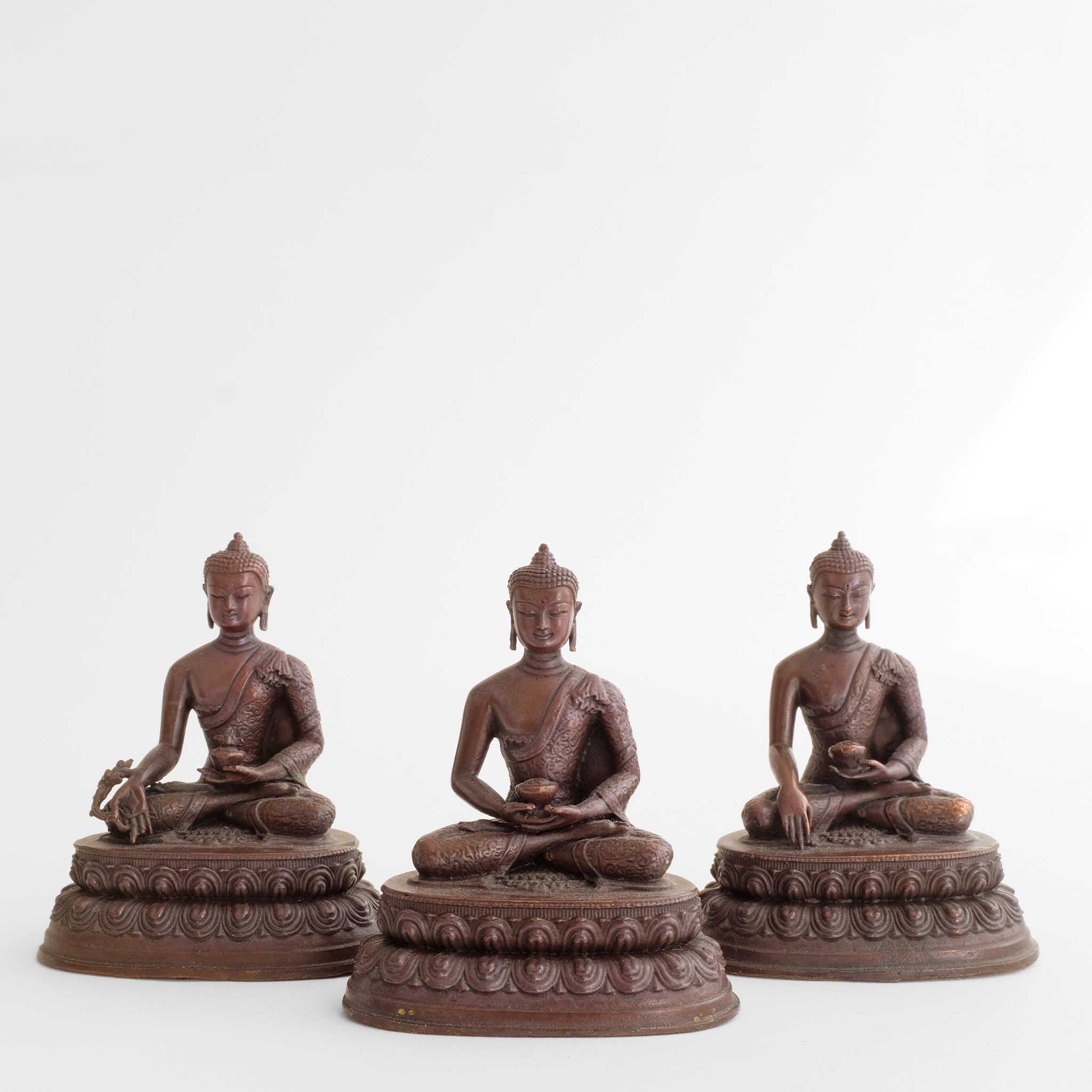 Drei kleine braune Buddha-Statuen aus oxidiertem Kupfer.