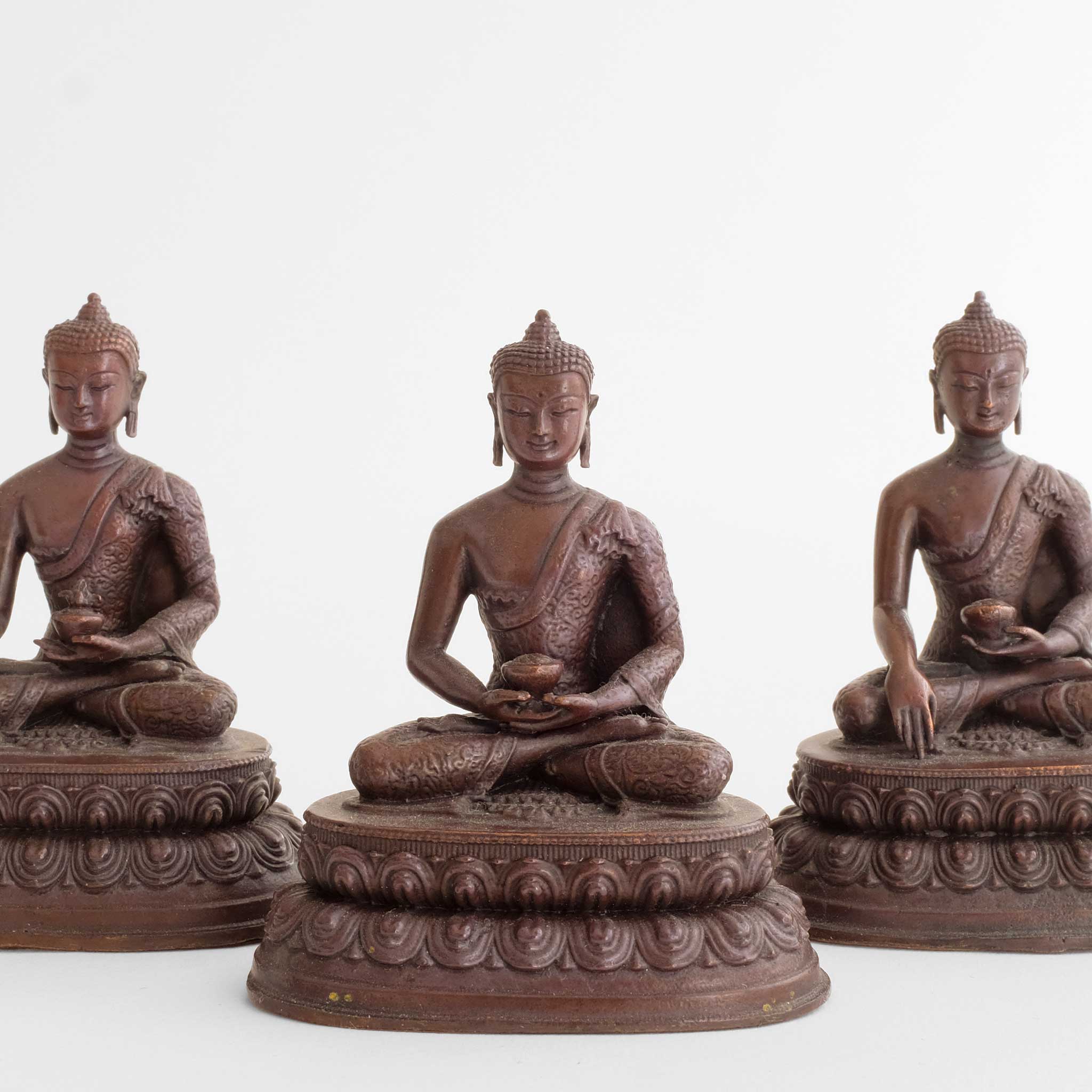 Drei kleine braune Buddha-Statuen aus oxidiertem Kupfer.