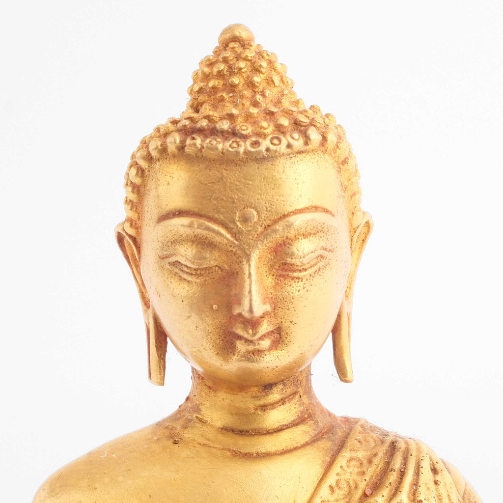 uddha Statuen Set, kleine vergoldete Figuren, detaillierter Kupferguss. Detailaufnahme des Gesichts einer der drei Figuren.