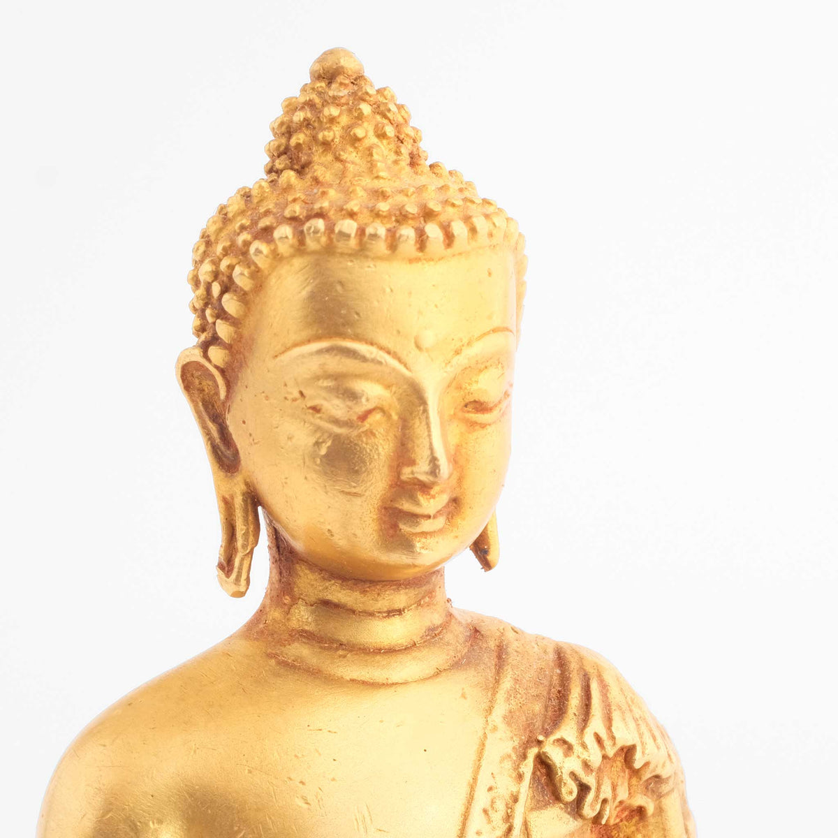 Buddha Statuen Set, kleine vergoldete Figuren, detaillierter Kupferguss. Seitliche Detailaufnahme des Gesichts einer der drei Figuren.