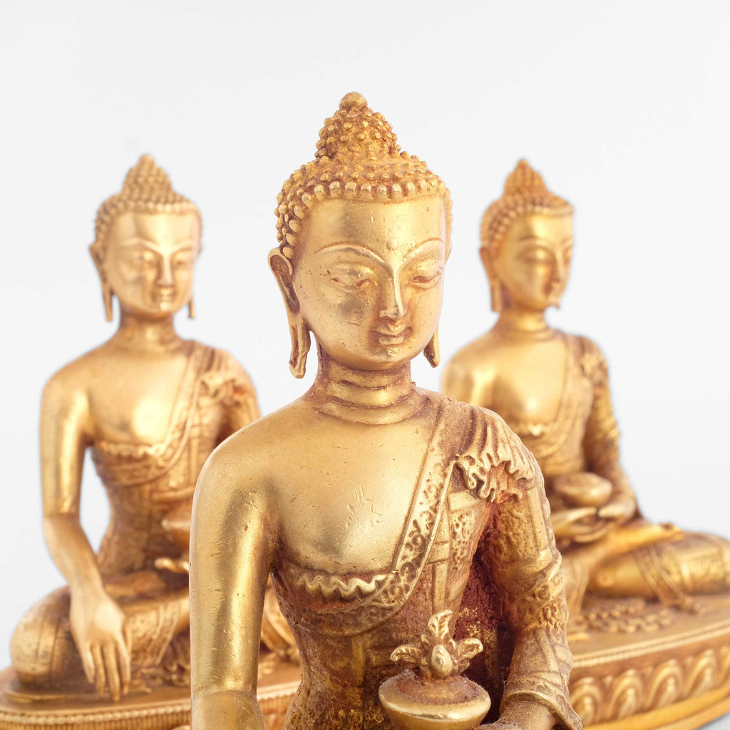 Buddha Statuen Set, kleine vergoldete Figuren, detaillierter Kupferguss. Nahaufnahme der Oberkörper.