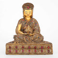 Der Guru Gampopa sitzt gerade mit verschränkten Beinen. In den zusammengelegten Händen hält er das Juwel des Dharma. Sein Hut, sein Gewand und sein Sockel sind mit Filigran Ornamenten gestaltet und mit farbigen Steinen akzentuiert.