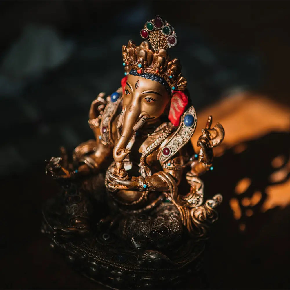 Ganesha Statue, Kupferfigur, im Wachsausschmelzverfahren gegossen, verziert mit feinem Filigran, versilbert und vergoldet. mit farbigen Steinen besetzt. Das Gesicht ist in Gold gefasst. Foto in der Werkstatt (Patan, Nepal) von Ayla Maagdenberg