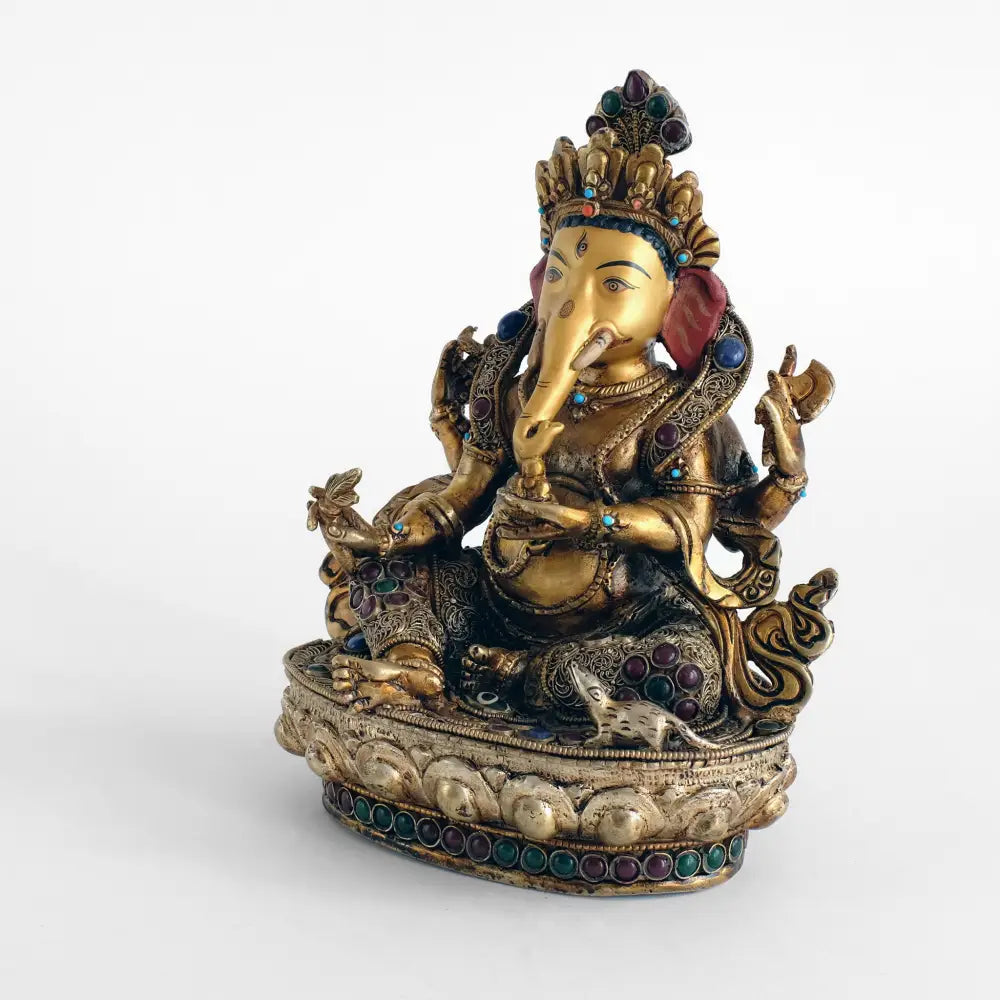 Ganesha Statue, Kupferfigur, im Wachsausschmelzverfahren gegossen, verziert mit feinem Filigran, versilbert und vergoldet. mit farbigen Steinen besetzt. Das Gesicht ist in Gold gefasst.