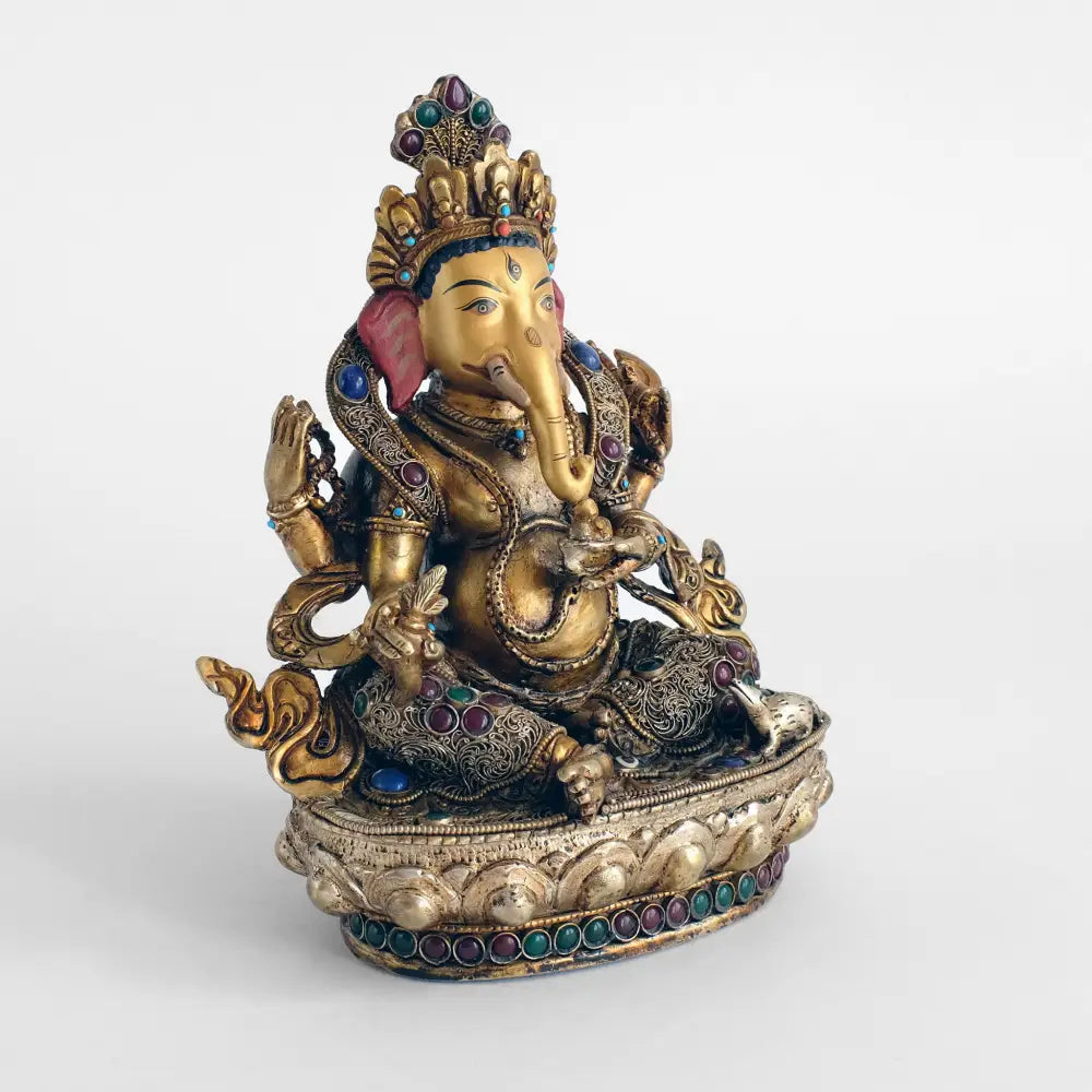 Ganesha Statue, Kupferfigur, im Wachsausschmelzverfahren gegossen, verziert mit feinem Filigran, versilbert und vergoldet. mit farbigen Steinen besetzt. Das Gesicht ist in Gold gefasst.