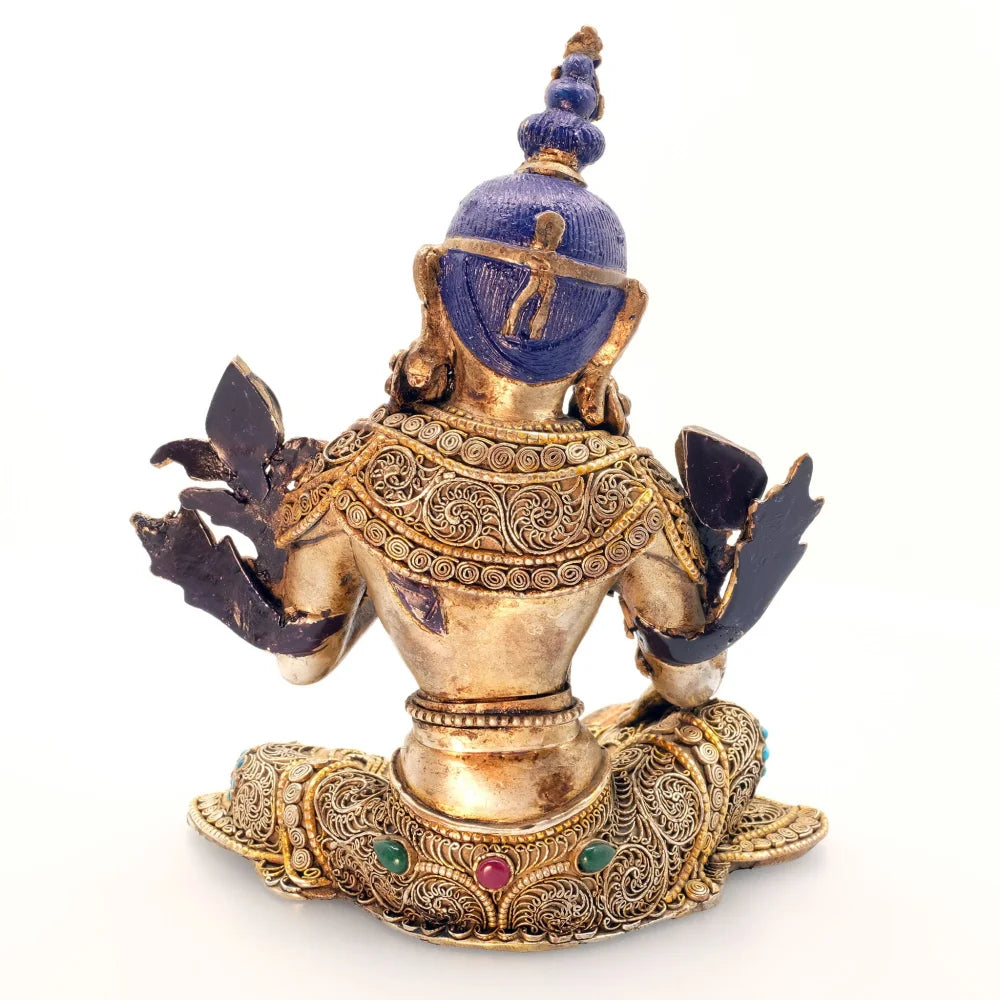 Rückansicht der Grünen Tara Figur. Ihre Robe ist mit feinen Filigran Ornamenten verziert, darin eingebettet farbige Steine. Die Statue ist vergoldet und versilbert. Das Haar ist mit blauer Acryfarbe bemalt.