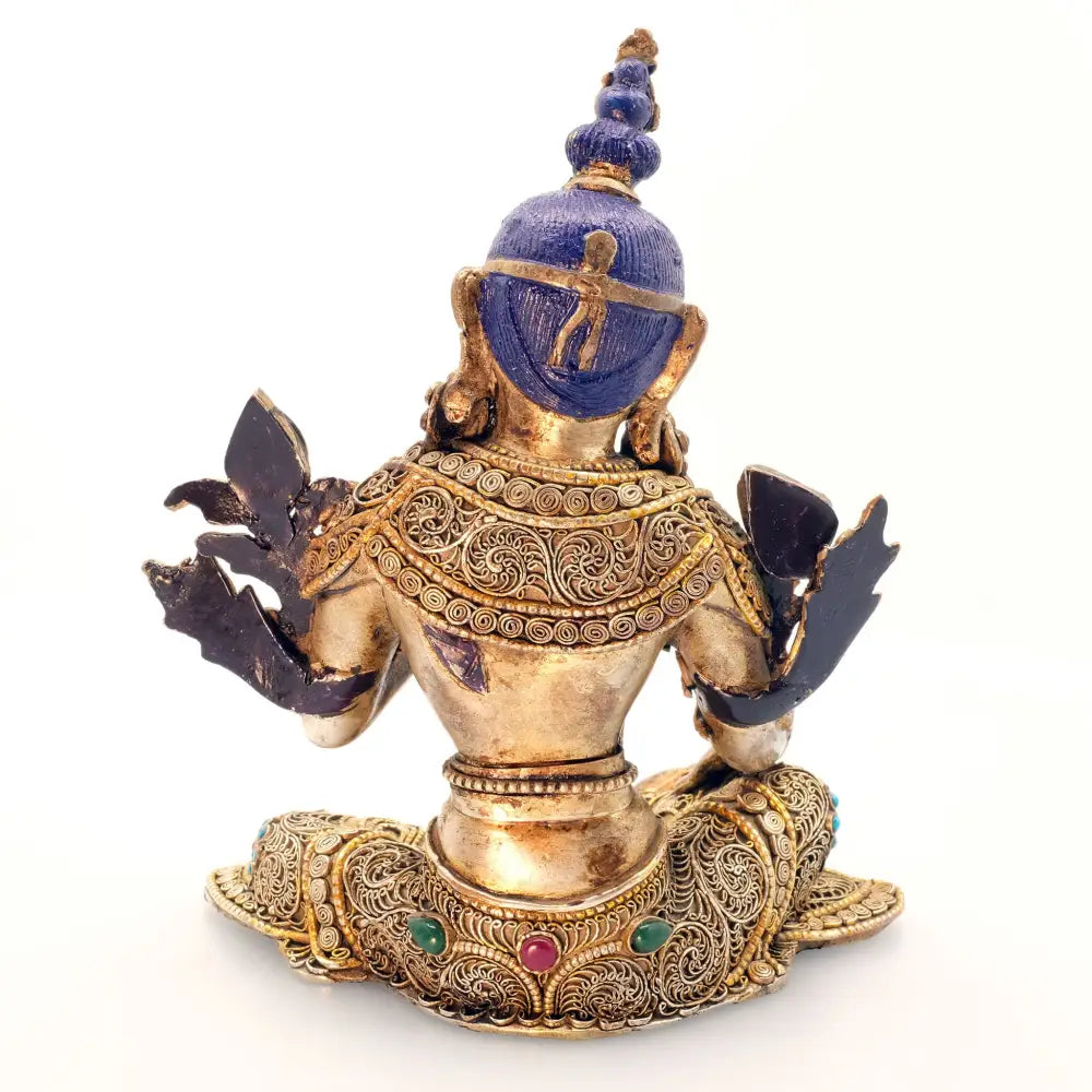 Rückansicht der Grünen Tara Figur. Ihre Robe ist mit feinen Filigran Ornamenten verziert, darin eingebettet farbige Steine. Die Statue ist vergoldet und versilbert. Das Haar ist mit blauer Acryfarbe bemalt.