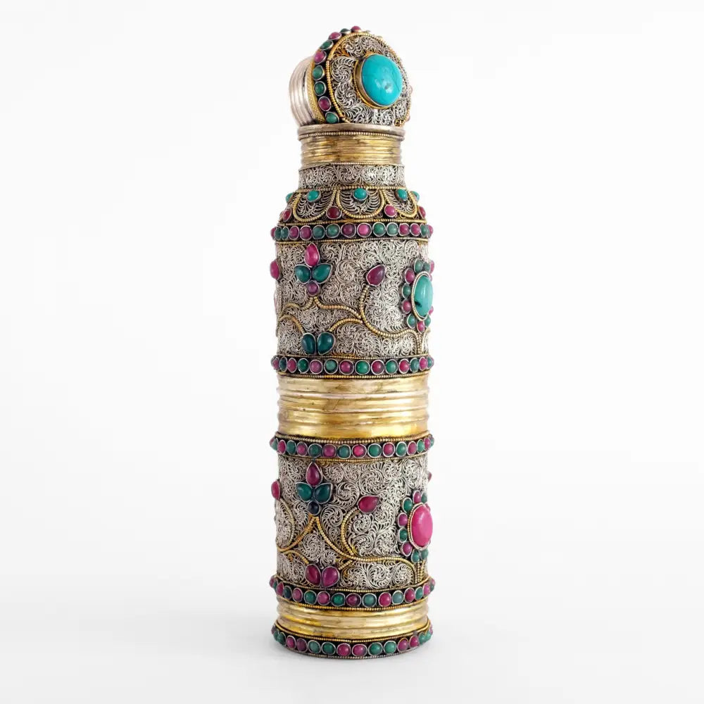 Versilberte Kupferflasche mit Schraubverschluss. Sie ist verziert mit feinen Filigran Elementen die spiralförmig angeordnet sind und mit farbigen Steine akzentuiert.