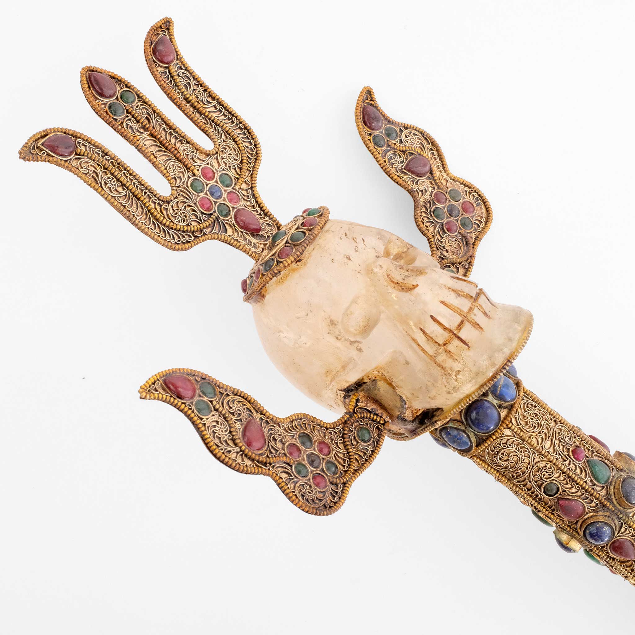 Seitenansicht des Kopfs mit Dreizack. Der Schädel ist aus Kristall geschnitzt. Die Kupferelemente sind mit Filigran verziert und mit farbigen Steinen besetzt.