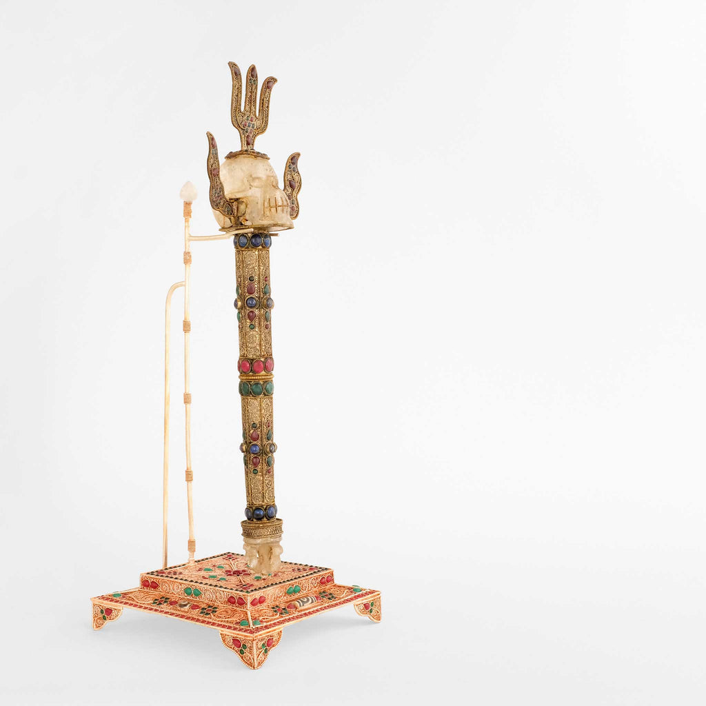 Khatvanga, tatrischer buddhistischer Stab  aufrecht auf einem verziertem Stand. Seitenansicht mit sichtbarer Halterung.