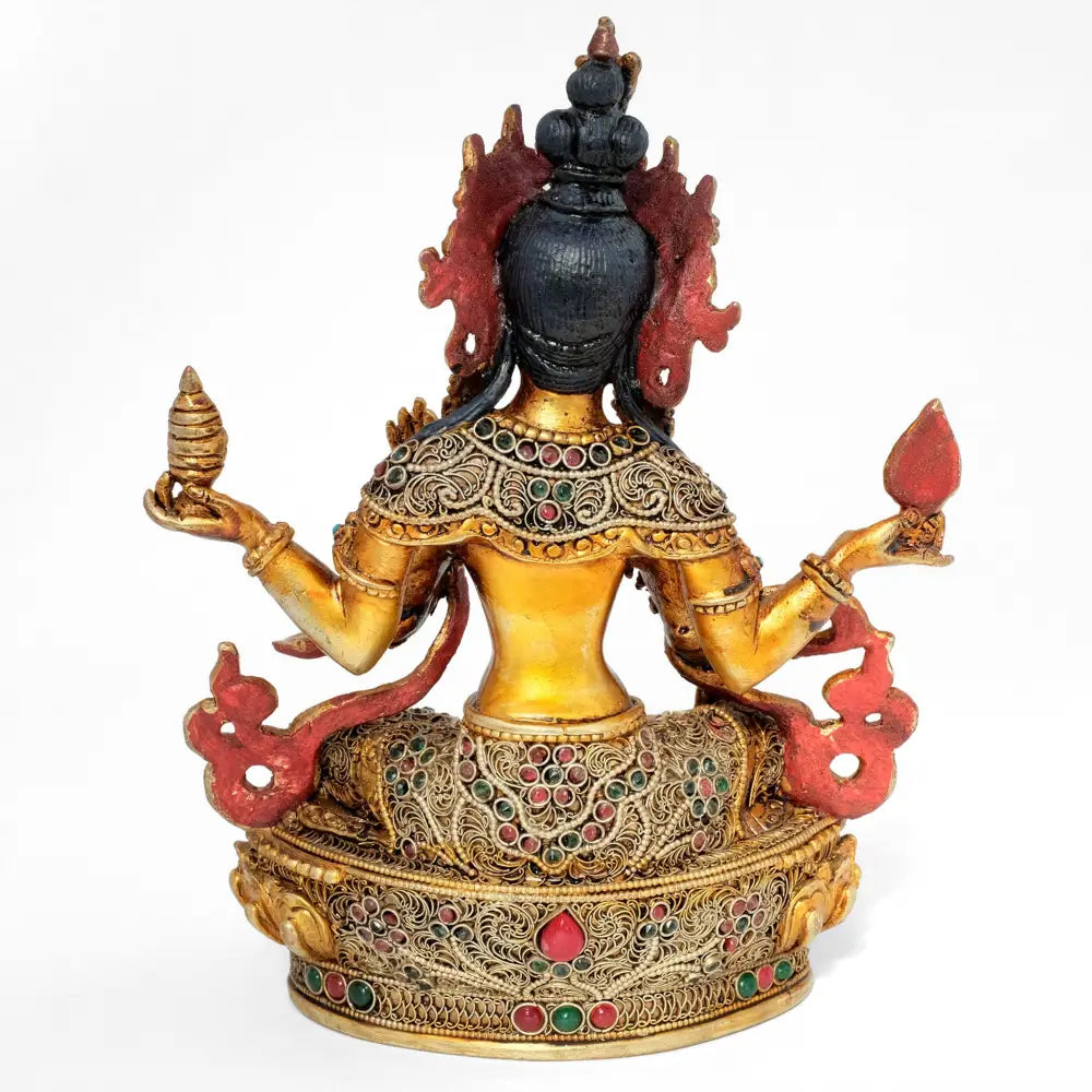 Die Rückseite der Lakshmi Figur ist ebenfalls vollständig bearbeitet. Das Filigran und die farbigen Steine bilden florale Ornamente.