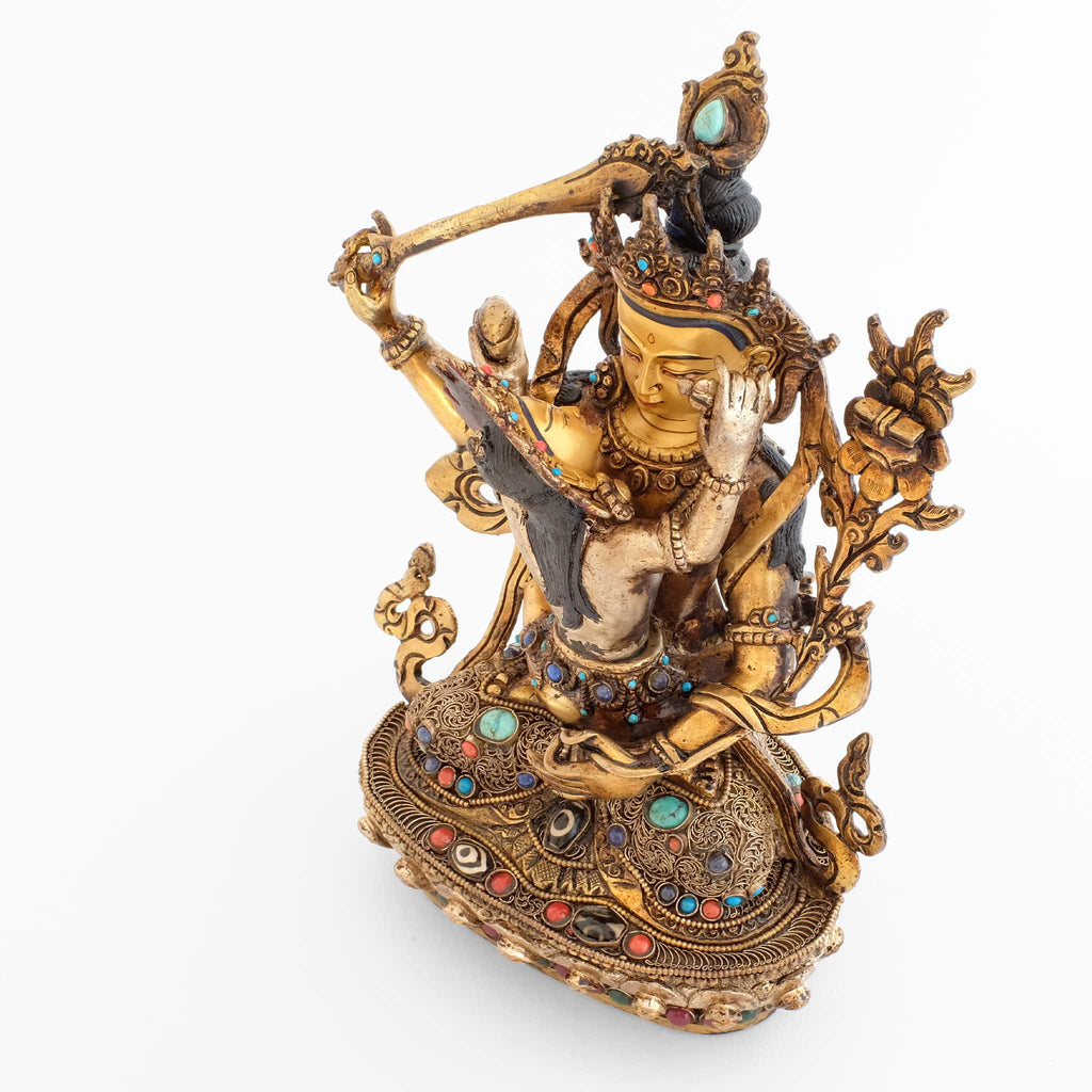 Manjushri in Yab Yum mit Gefährtin, Seitenansicht der Statue mit Filigran und farbigen Steinen. Der Lotus Sockel ist mit gefassten dzi Perlen akzentuiert.