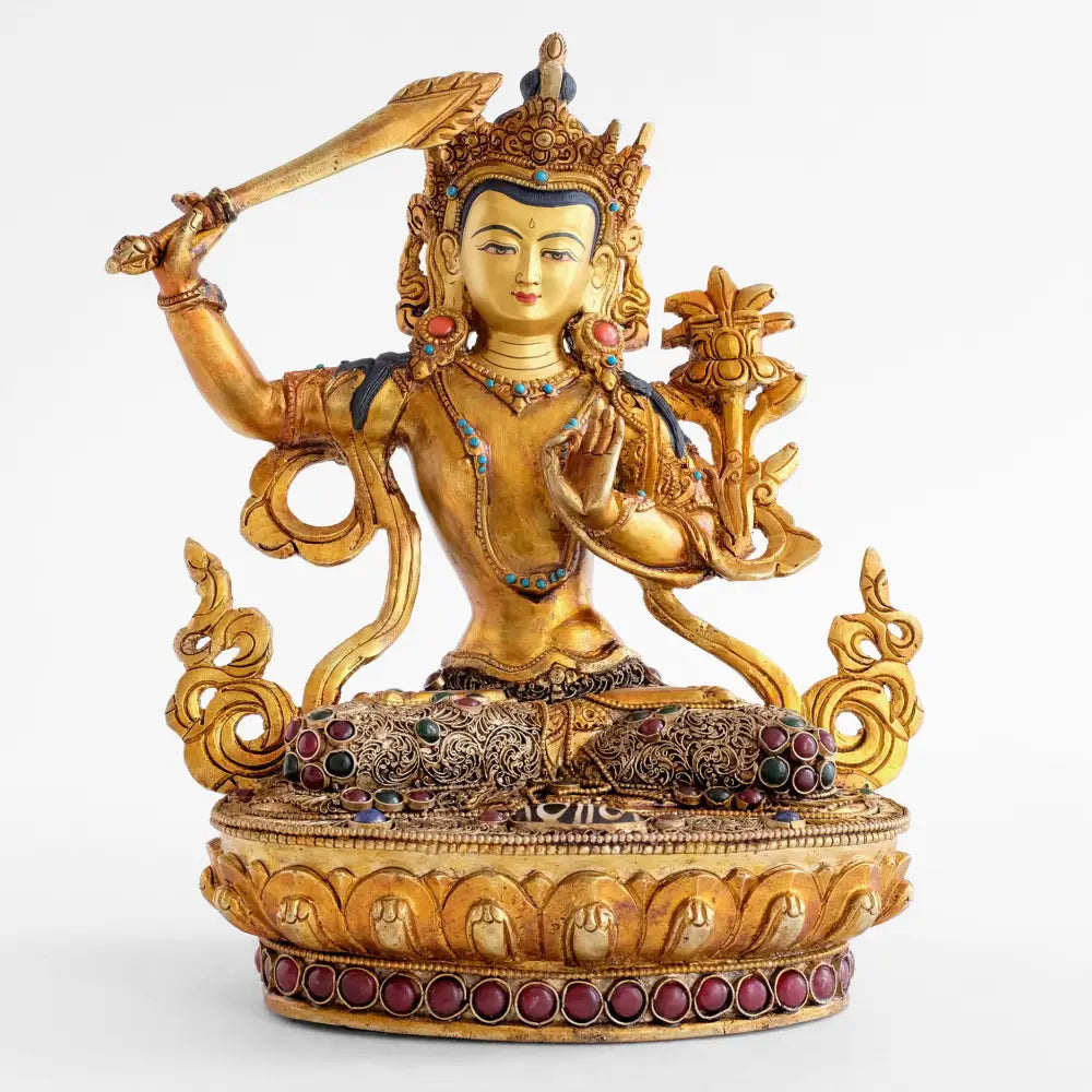 Manjushri-Statue von vorne. Vergoldete Figur, der Gott der Weisheit hält das geflammte Schwert in seiner rechten Hand und die Prajnaparamita mit einer Lotusblume auf seiner rechten Schulter.