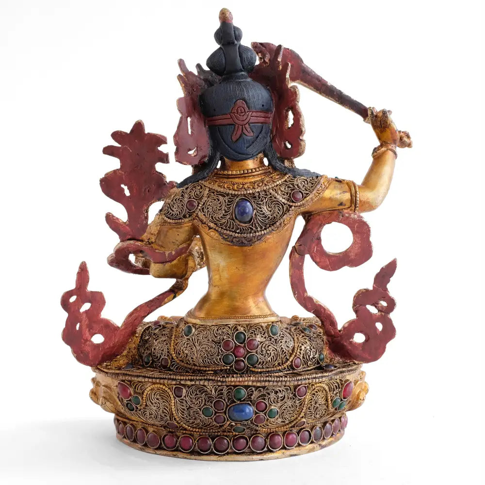 Die Rückseite der Manjushri Statue ist ebenfalls bearbeitet. Seine Robe ist mit feinen Filigran Ornamenten besetzt.