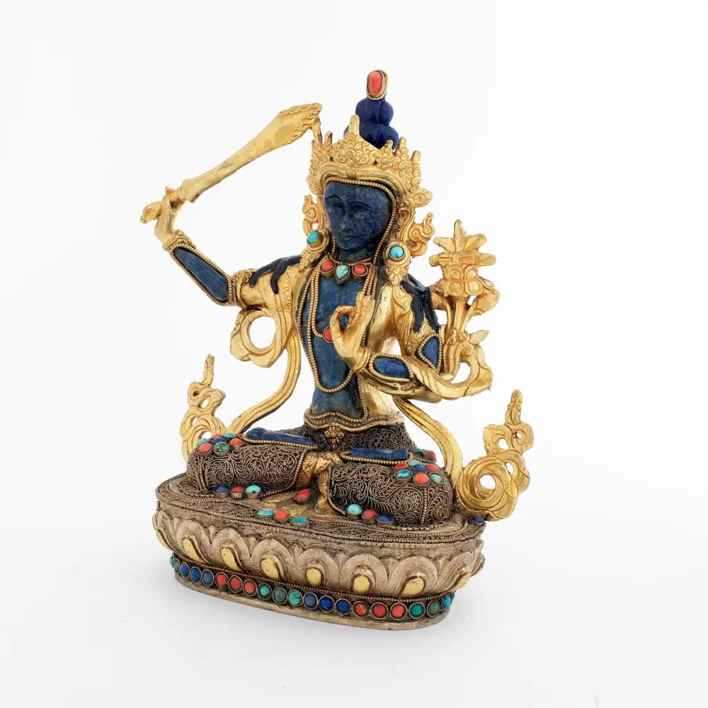 ManjushriStatue, der Körper ist aus einem Kupferguss, feuervergoldet, das Gesicht, der Bauch, die Unterarme und Füße sind aus Lapislazuli geschnitzt. Seine Robe und der Lotus Sockel sind mit Filigran besetzt, versilbert und vergoldet, verziert mit gefassten Türkis, Koralle und Lapislazuli. 