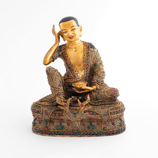 Jetsun Milarepa statue, der Meister der Kagyu Schule, er sitzt entspannt auf einem Thron der mit einem Gazellenfell bedeckt ist. In seiner linken Hand hält er eine Bettelschale. Sein Gewand und der Thron sind mit vergoldentem Perldraht und versilberten Filigran Elementen verziert.