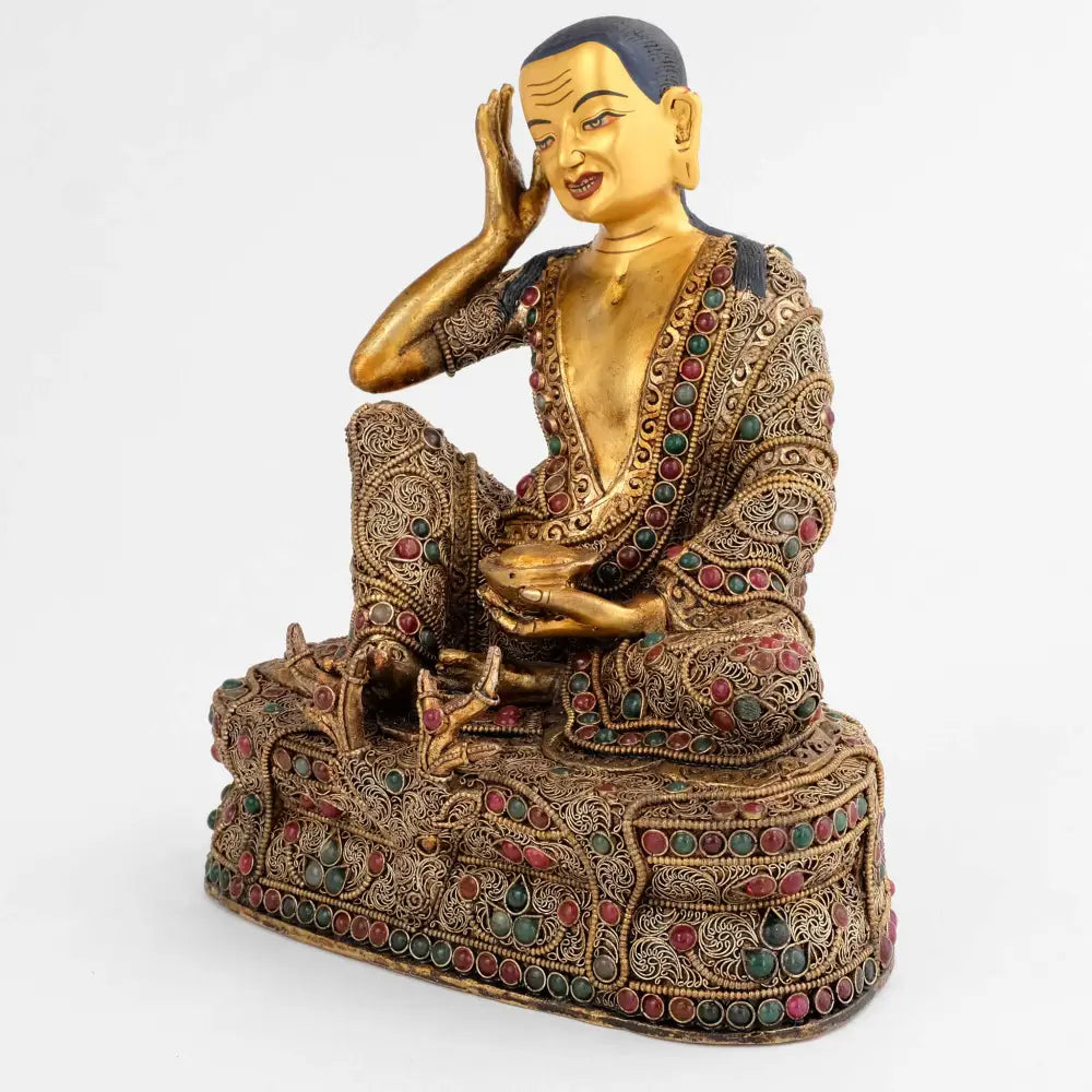 Jetsun Milarepa statue, der Meister der Kagyu Schule, er sitzt entspannt auf einem Thron der mit einem Gazellenfell bedeckt ist. In seiner linken Hand hält er eine Bettelschale. Sein Gewand und der Thron sind mit vergoldentem Perldraht und versilberten Filigran Elementen verziert.