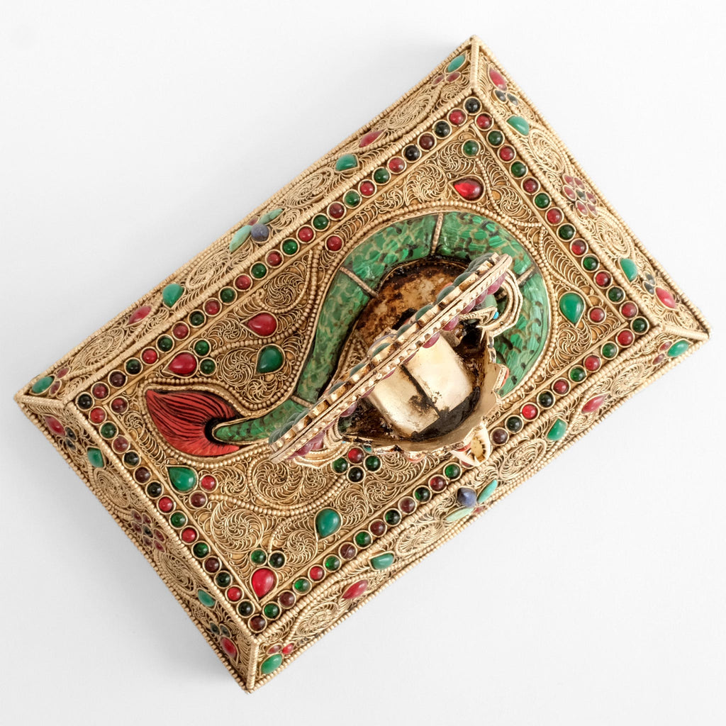 Sockel der Naga Kanya Statue von oben gesehen, spiralförmige Muster und farbige gefasste Steine.