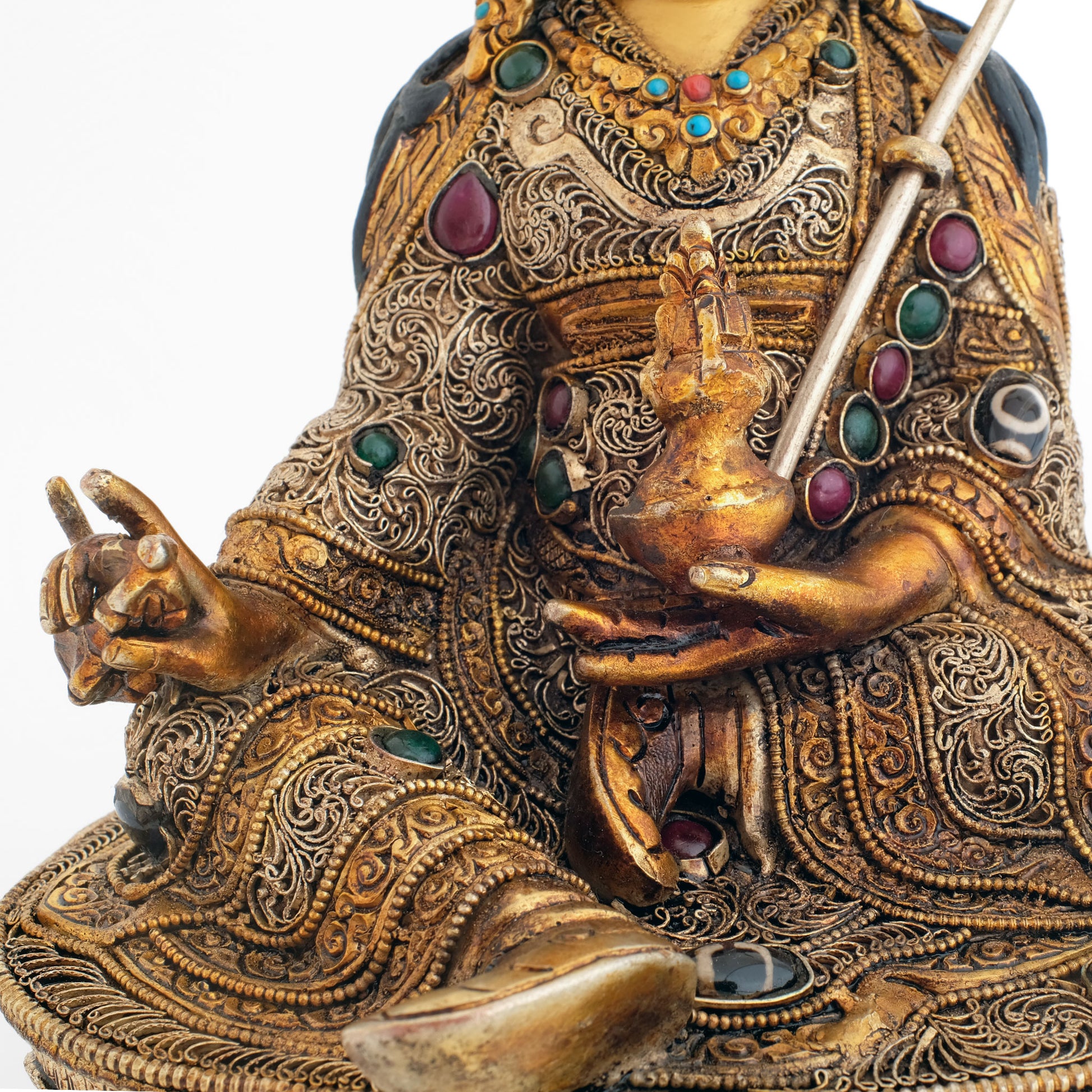 Guru Rinpoche Statue, in der rechten Hand hält er ein Vajra, in der linken eine Schale mit Amrita. Er trägt eine mit feinen Filigranelementen reich verzierte Robe.